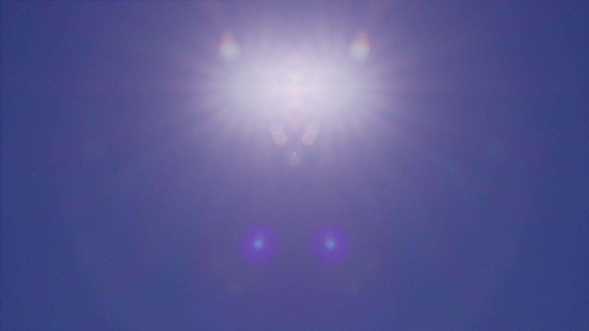 Shot of a dazzling white blurred sun sitting high in the sky on a bright blue summer's day