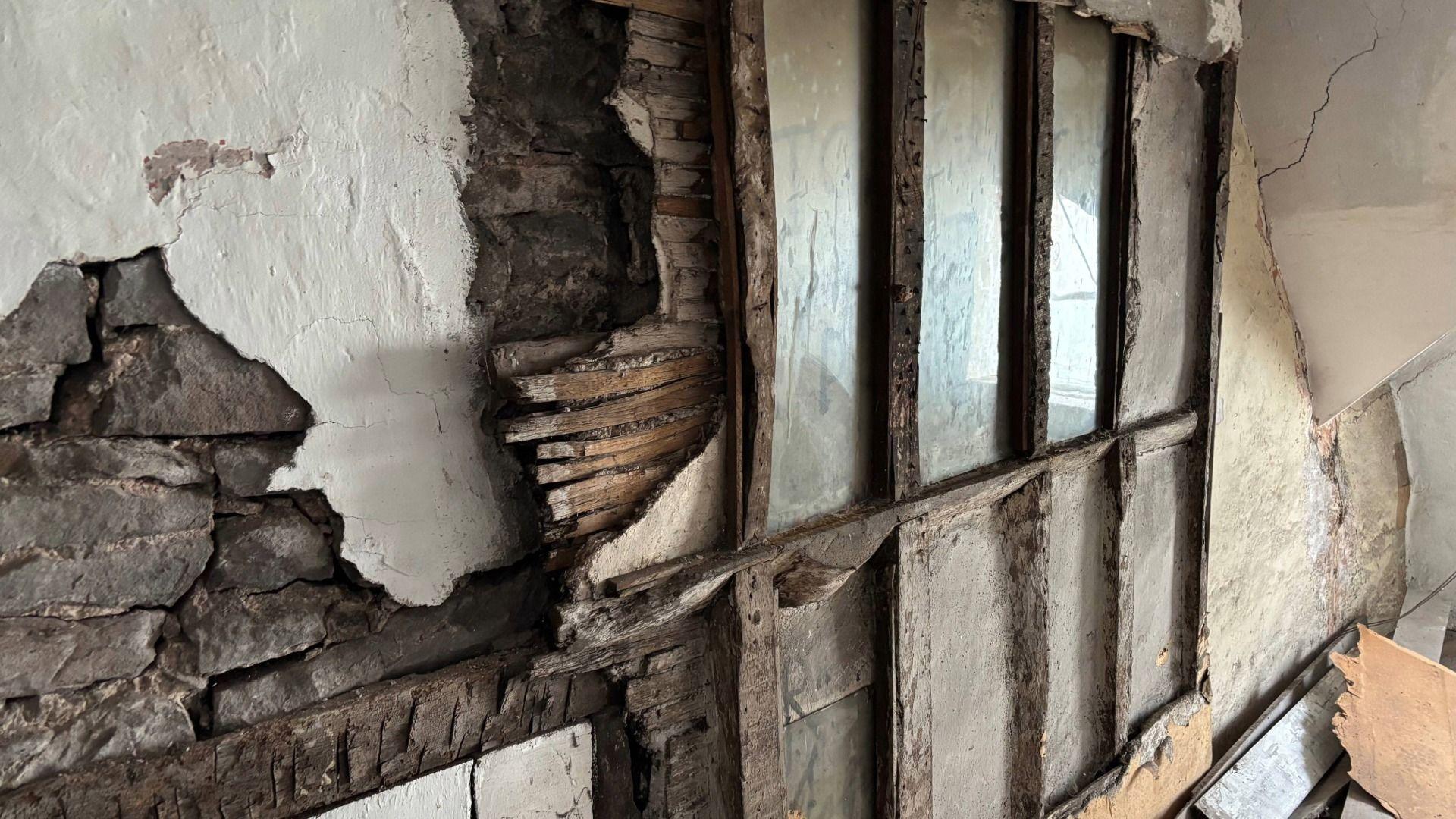 Llun o wal wedi ei rwygo gan ddatgelu panel o'r 17ganrif o'r capel cudd yn atig y plas.