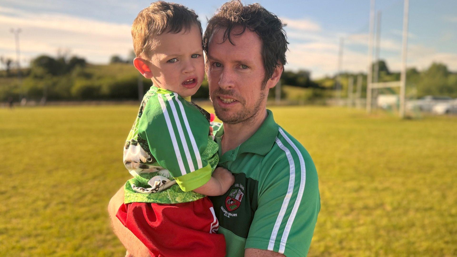 Conor Holland and his son staring at the camera