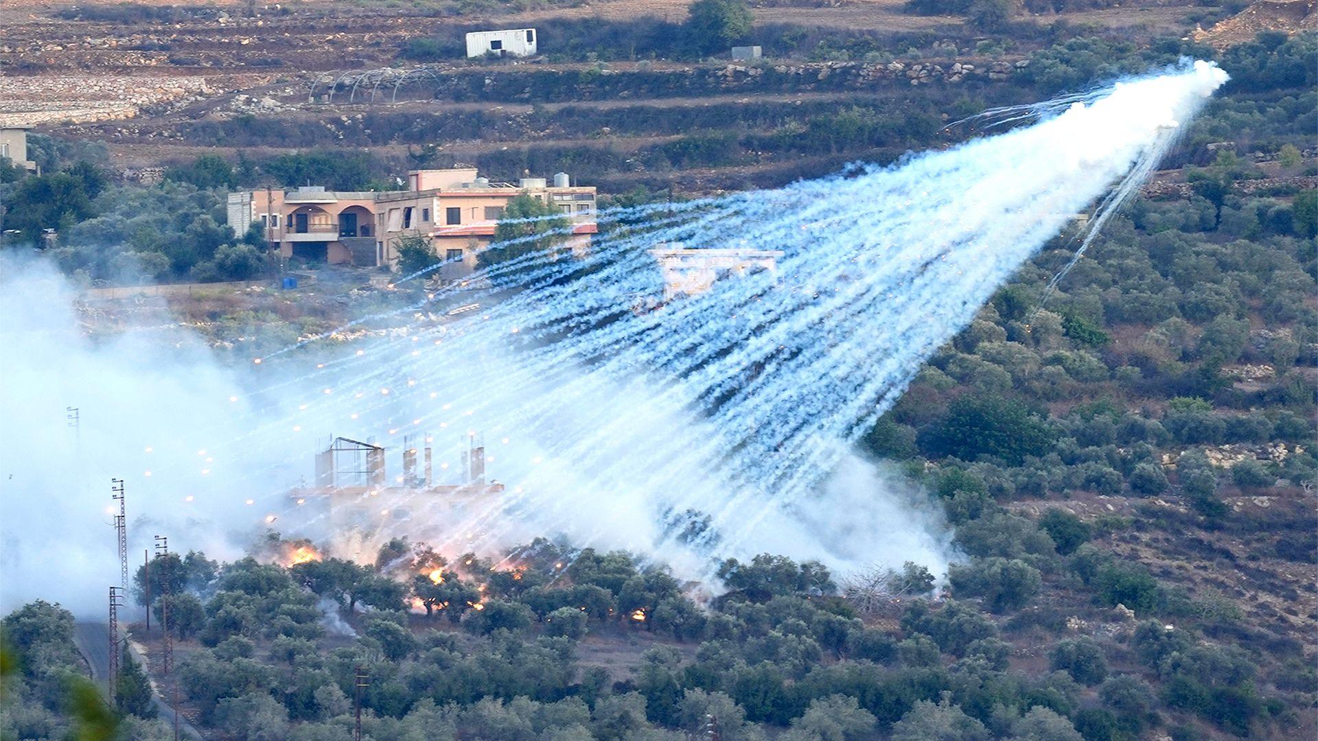 A shell that appears to be white phosphorus from Israeli artillery explodes over a house in al-Bustan, a Lebanese village along the border of Israel