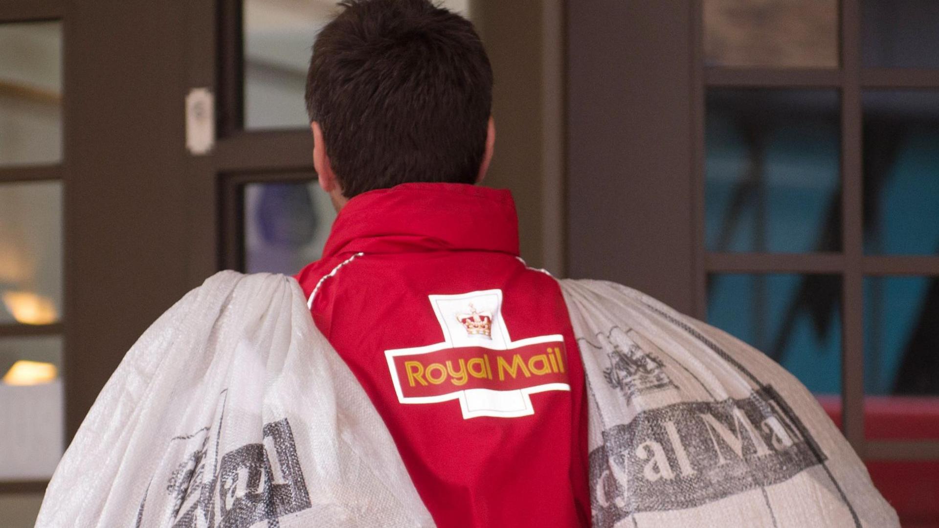 A postman carrying bags of mail.
