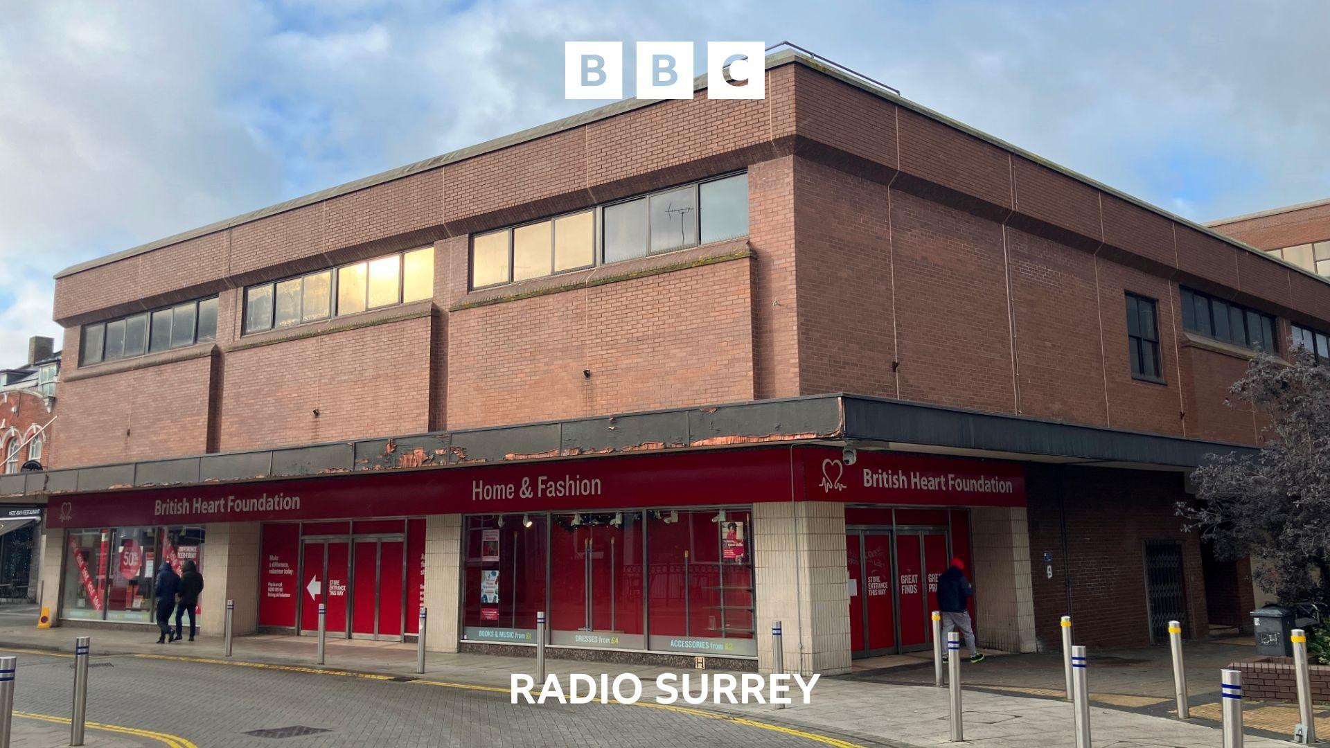 A 2-storey brick building is shown. The ground floor contains a red fronted charity shop.