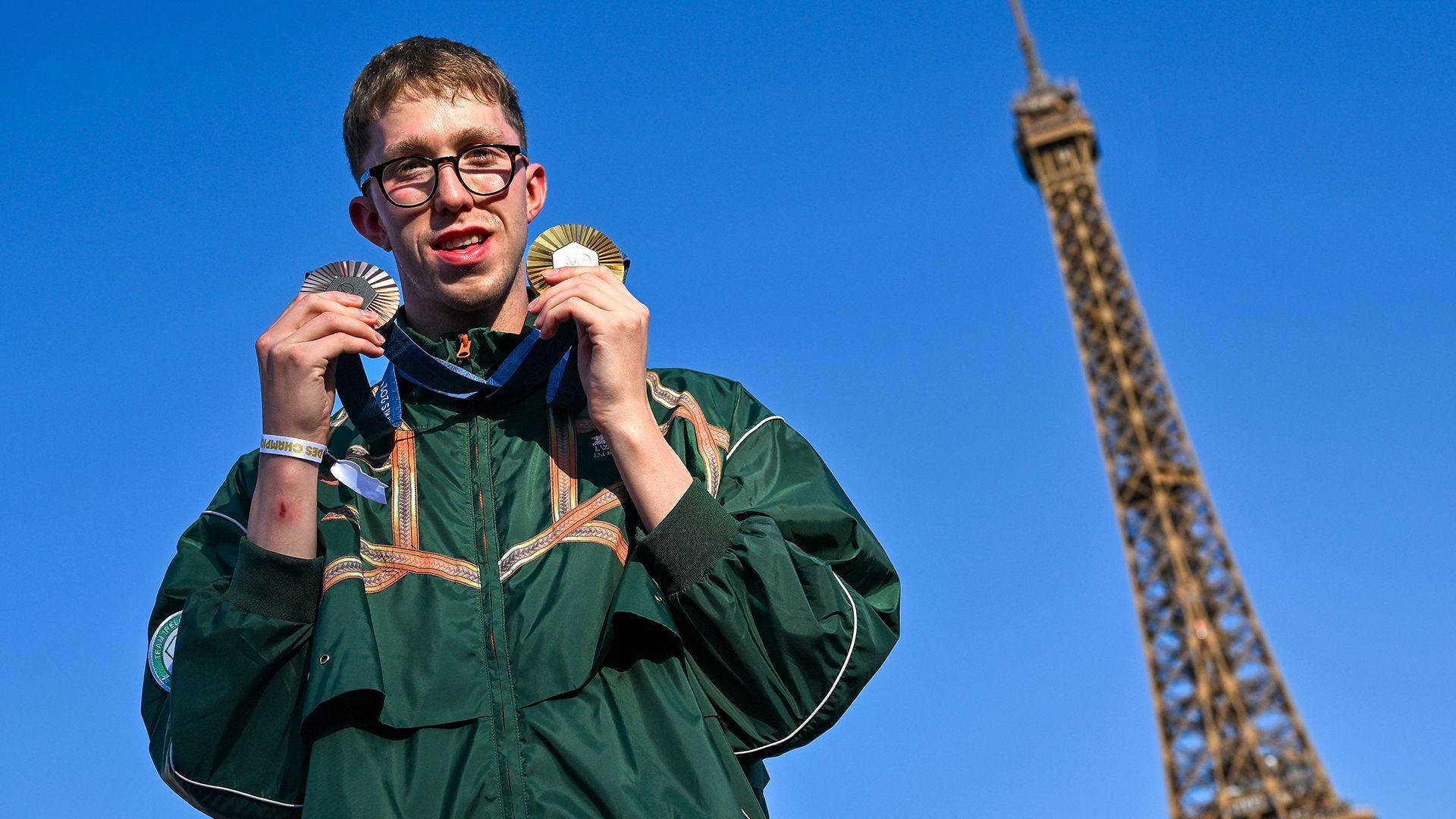 Daniel Wiffen celebrates with his two medals in front of the Eiffel Tower
