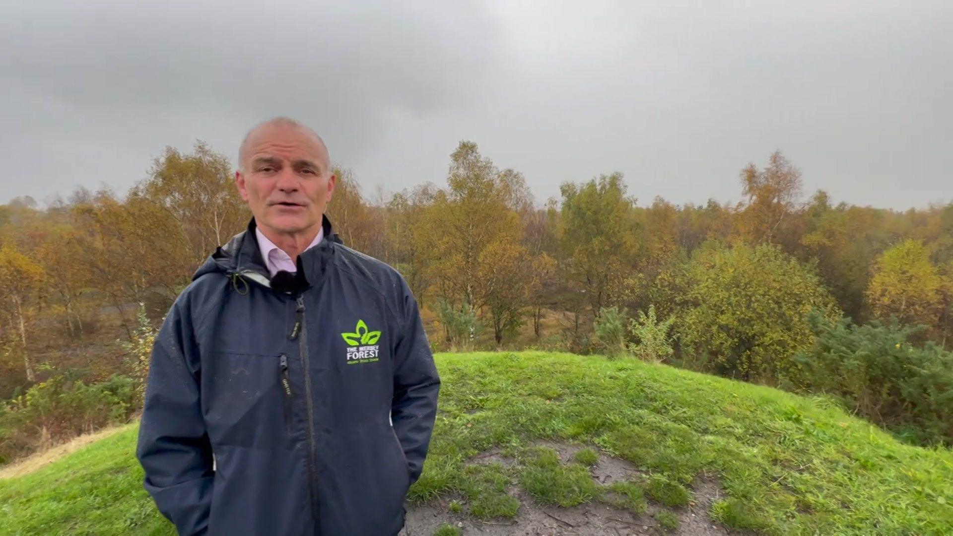 Paul Nolan has short grey hair and is wearing a dark blue jacket with The Mersey Forest logo