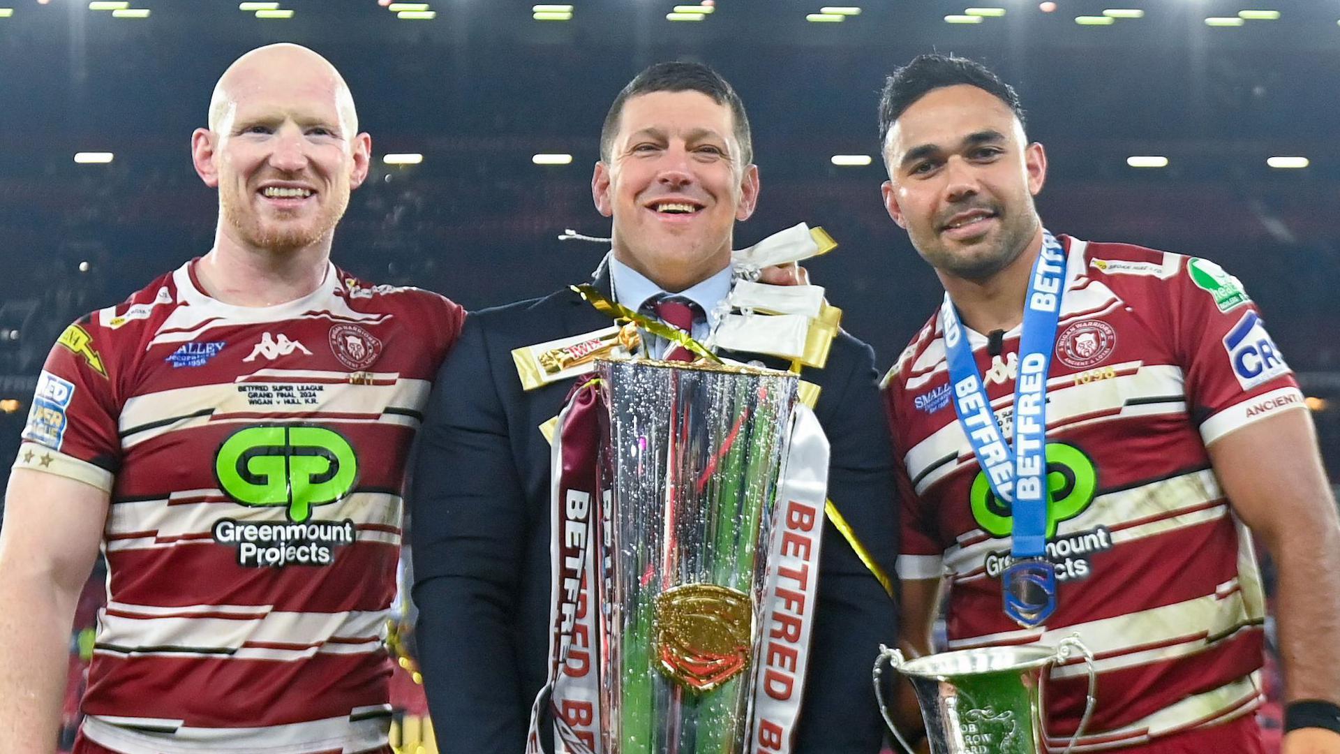 Wigan Warriors captain Liam Farrell, head coach Matt Peet and Rob Burrow Award winner Bevan French pose with the Super League trophy after winning in the 2024 Super League Grand Final