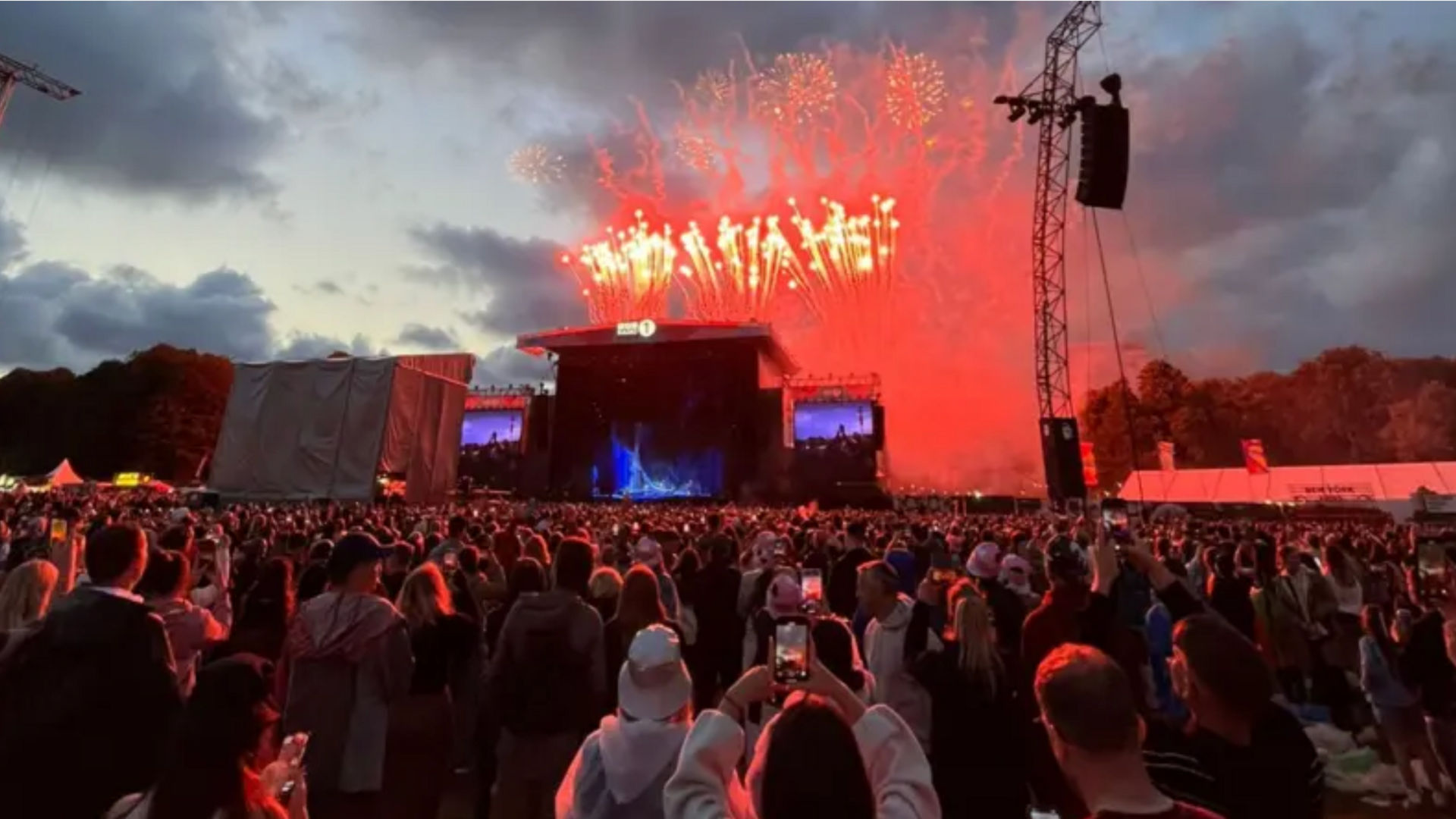 Crowds gathered in front of the main stage as fireworks are seen behind the stage