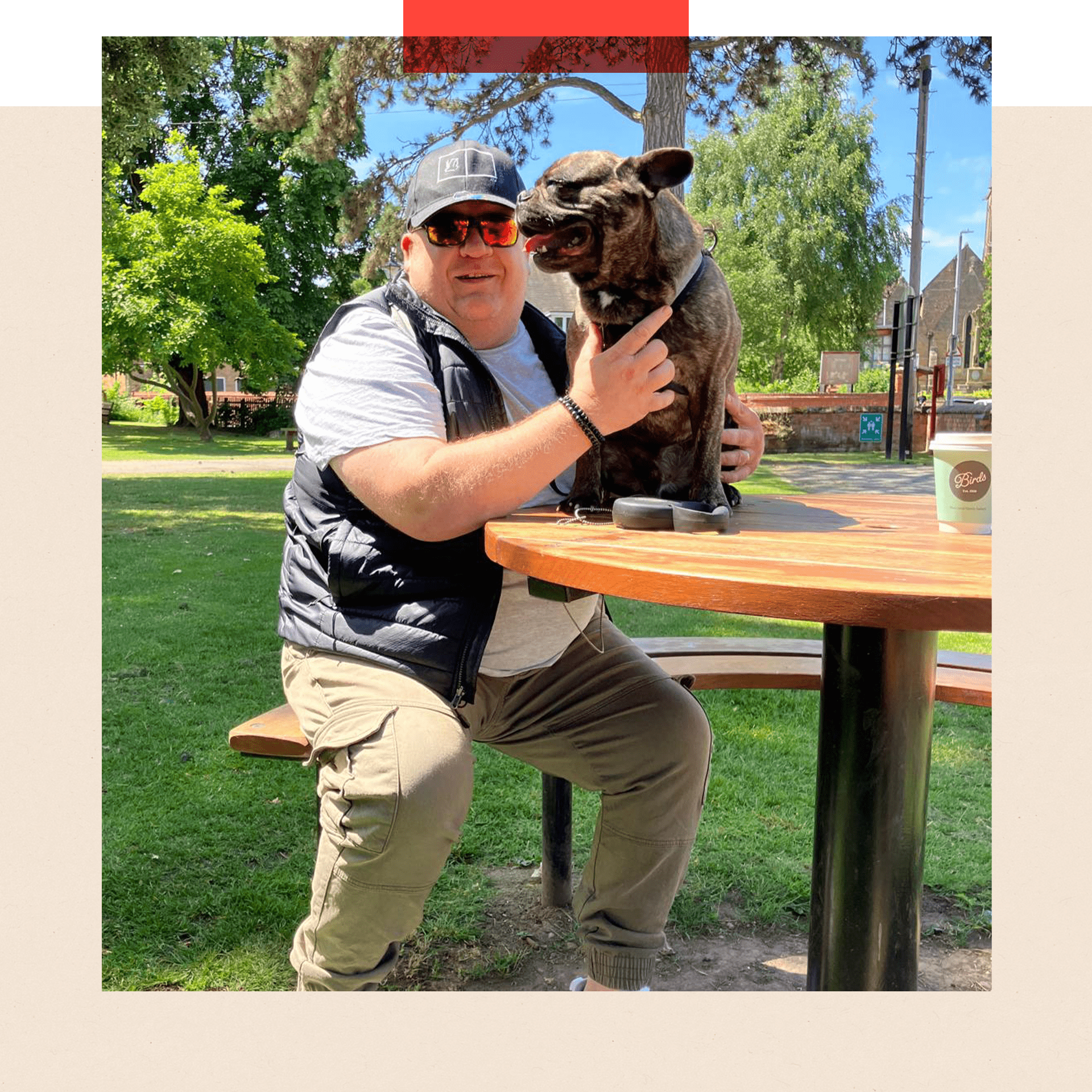 Robbie Davison sits at a picnic table with his daughter’s dog Joey