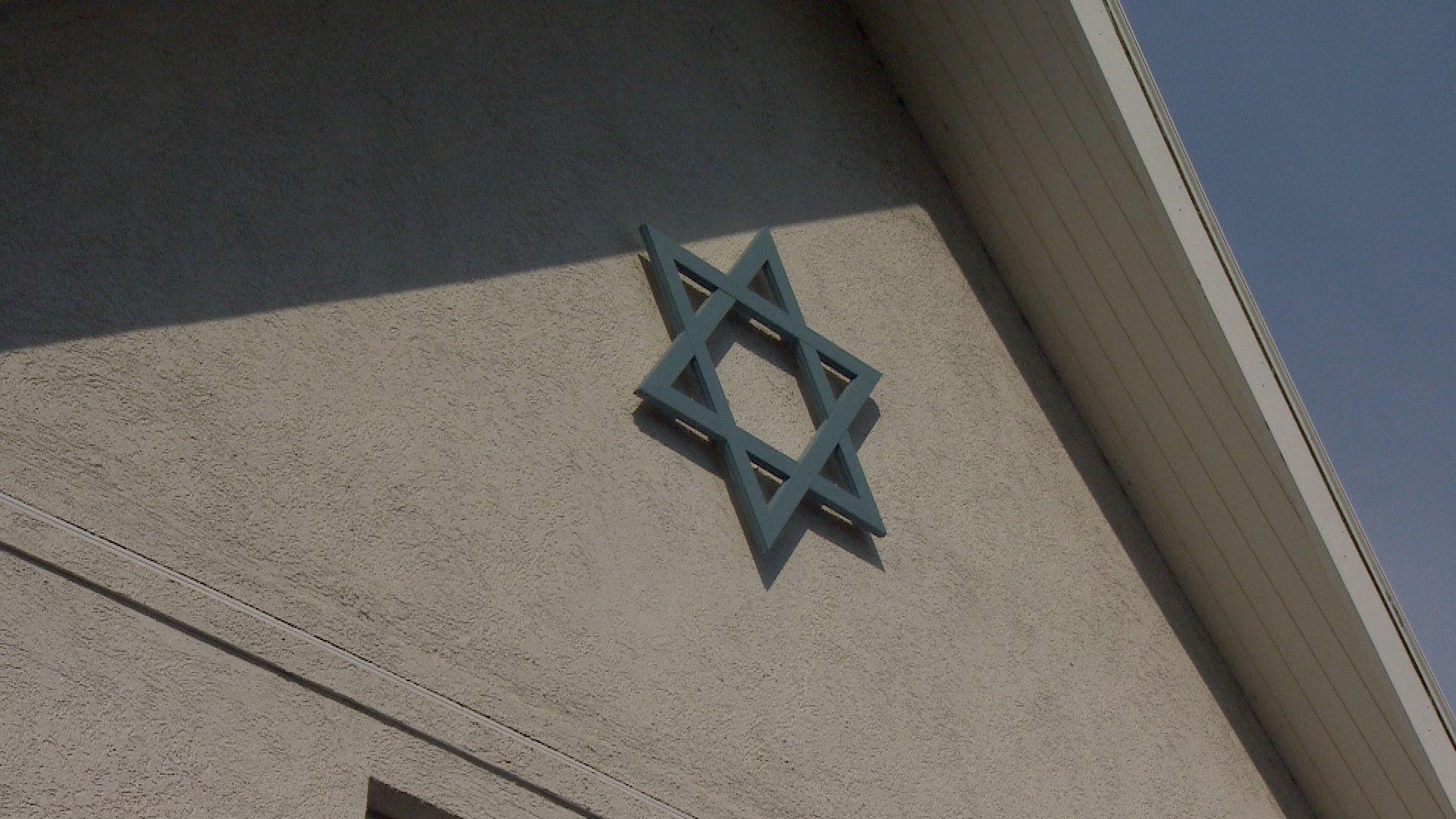 A Jewish Synagogue building - a white building with the jewish star on it.