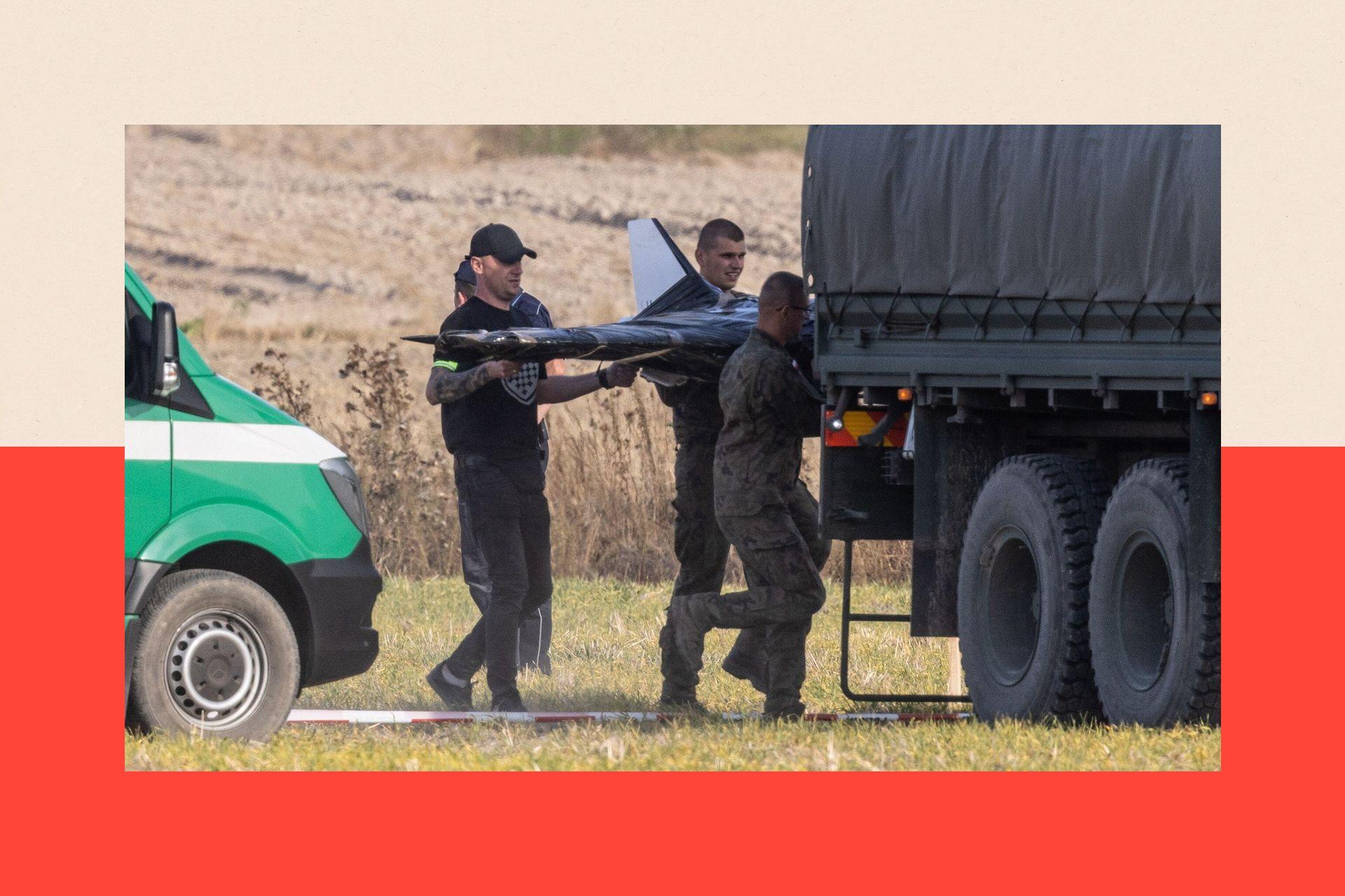 Three men carry a drone into a lorry