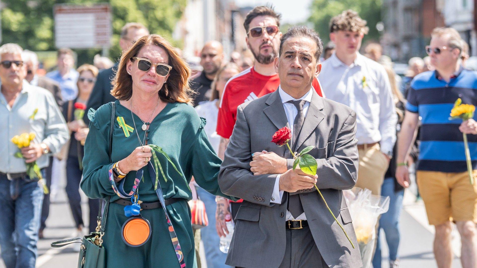 Emma Webber and Dr Sanjoy Kumar walk arm in arm during a memorial