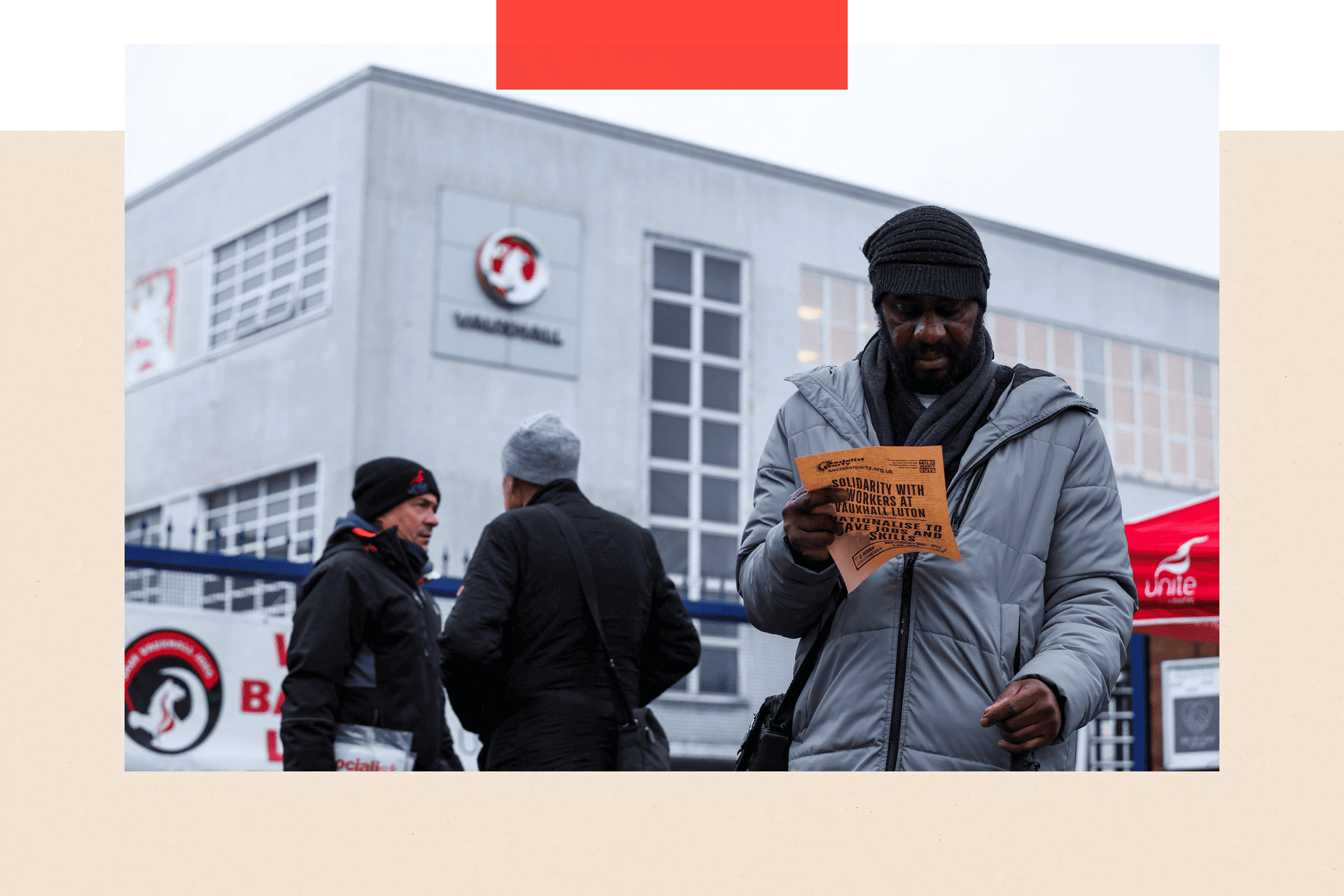 A man holds a leaflet as workers protest following Stellantis' announcement of its plan to shut its Vauxhall van factory in Luton