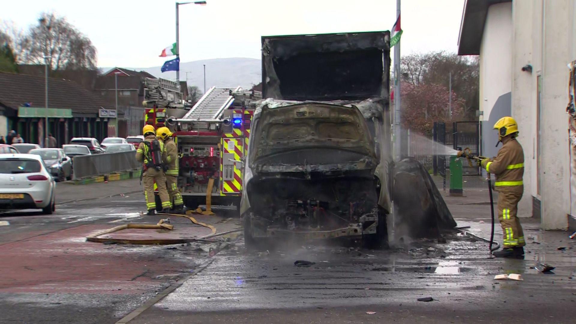 A firefighter puts out a fire after a van was set alight in Londonderry 