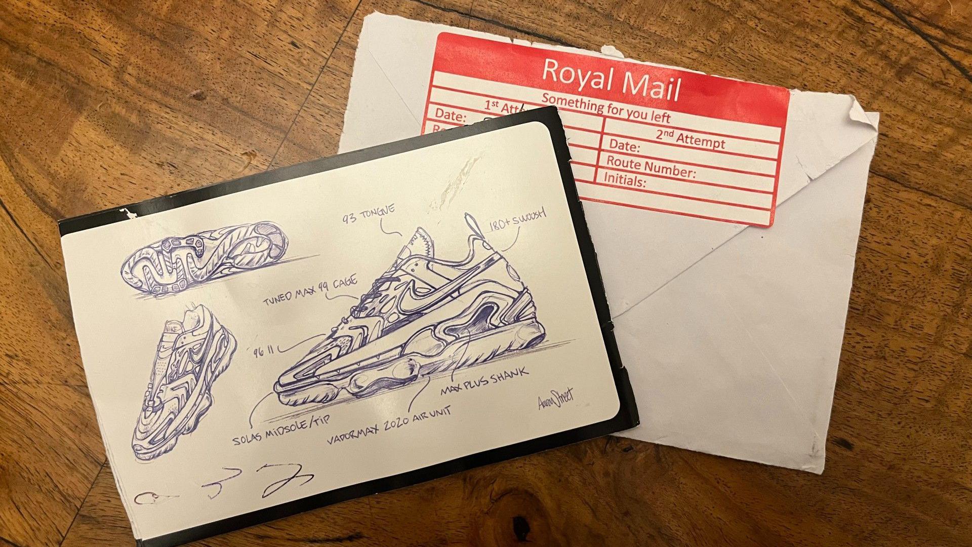 An opened Royal Mail stamped envelope and a brochure advertising trainers. They are laid on top of each other on a dark wooden surface.