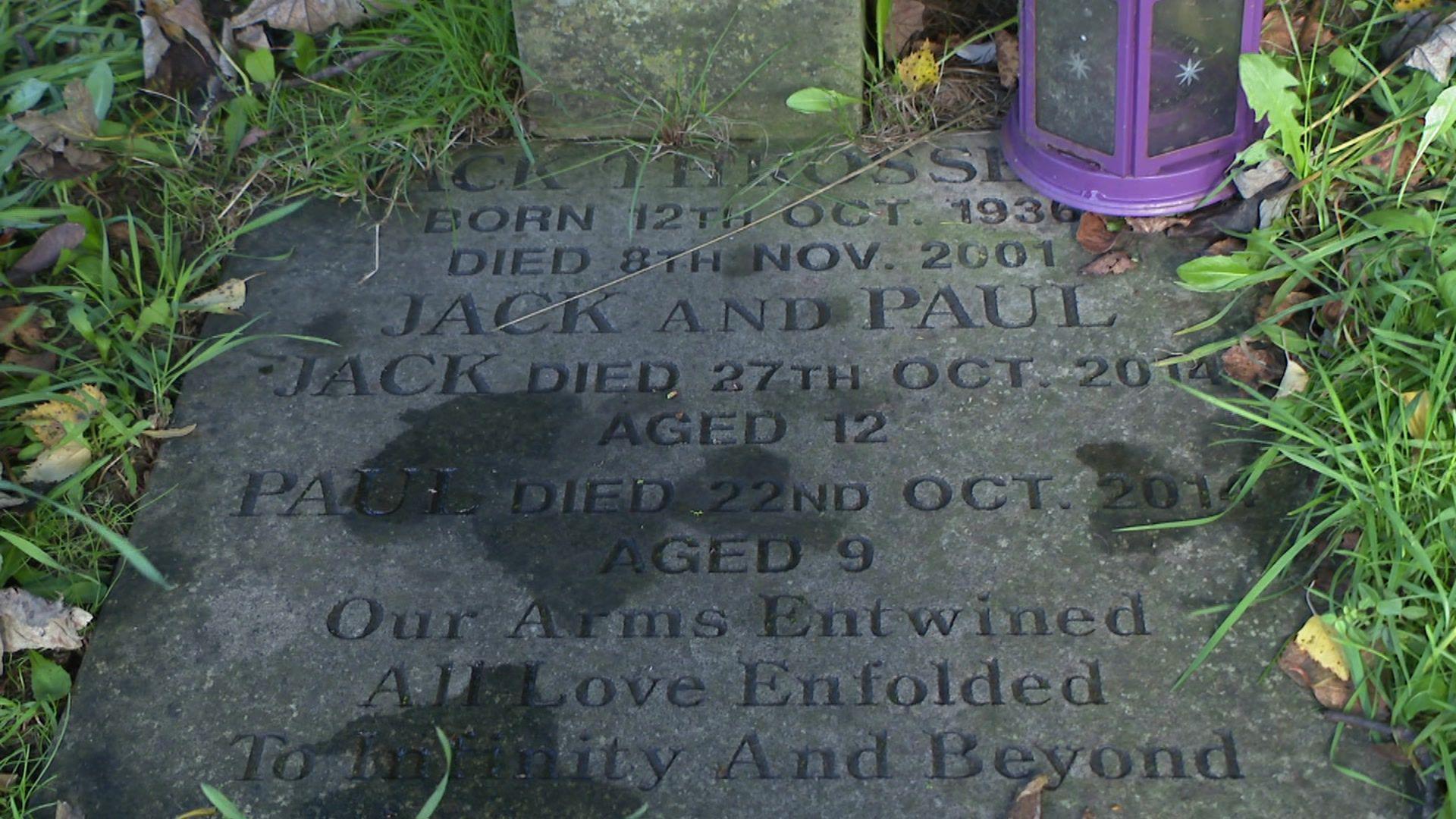 A grey gravestone, engraved with dark grey writing, that reads: Jack and Paul. Jack died 27th Oct. 2014, aged 12. Paul died 22nd Oct. 2014, aged 9. Our Arms Entwined All Love Enfolded To Infinity And Beyond.