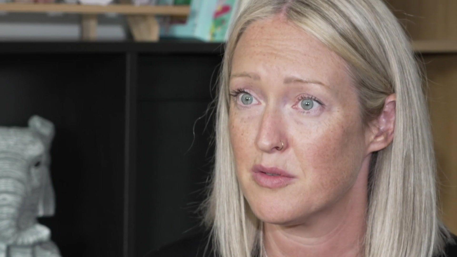 Esther Ghey with long blonde hair and green eyes and gold nose ring sitting in a room with a black cabinet behind her.