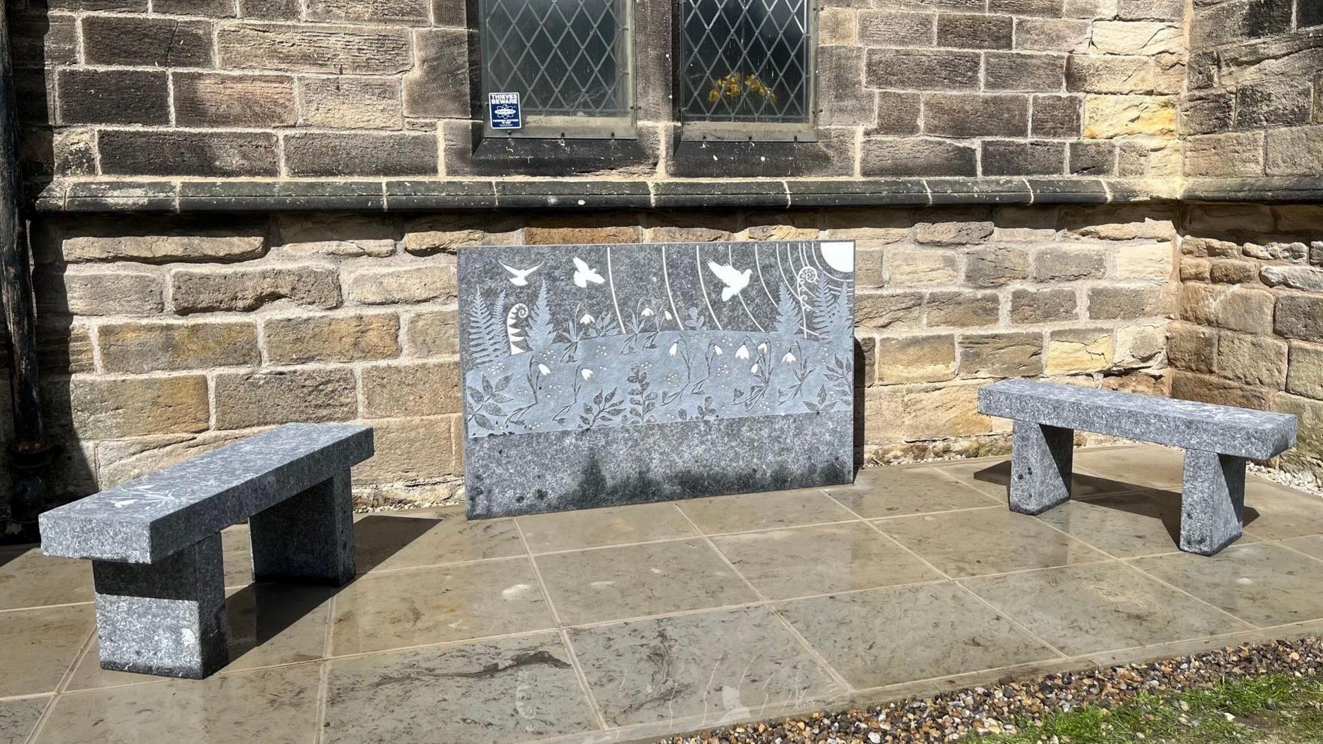 A memorial stone with two benches either side