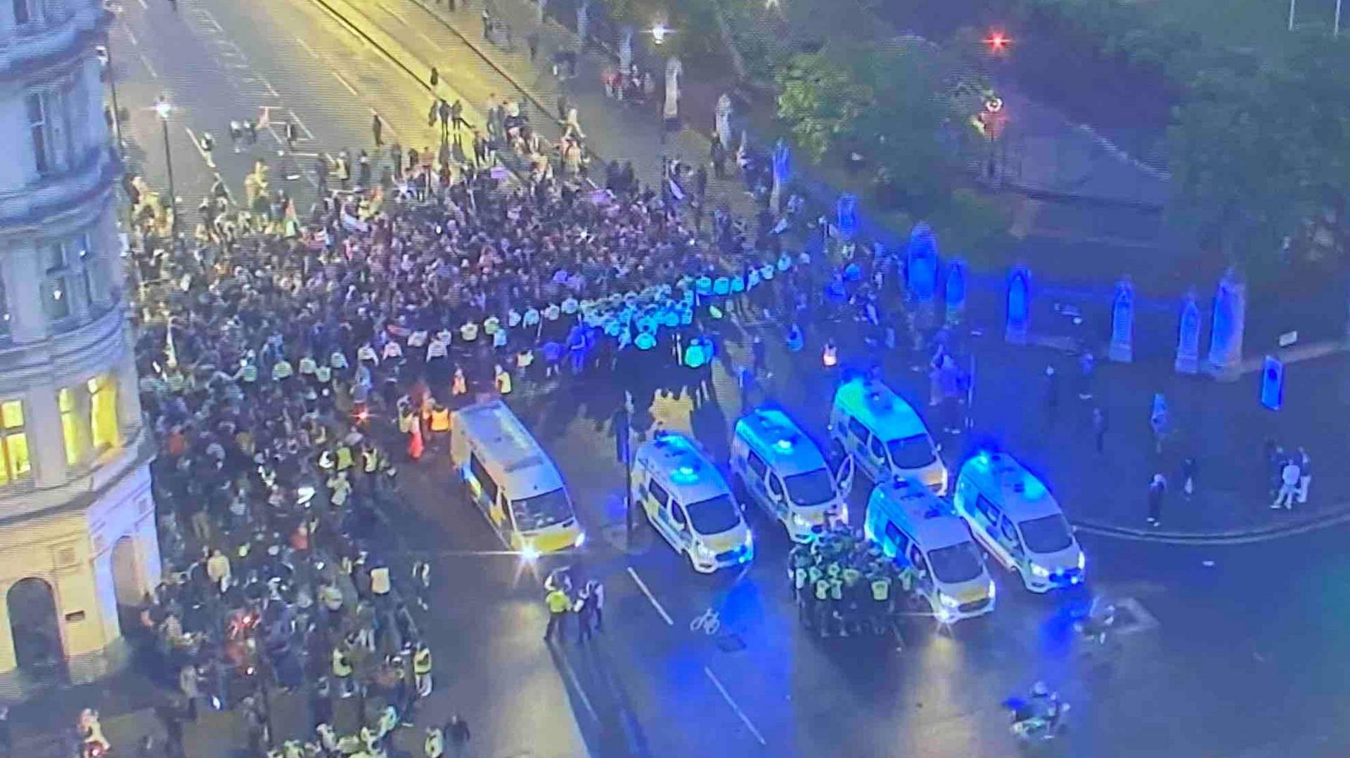 A far-away still taken of a crowd of protesters gathering in Whitehall 