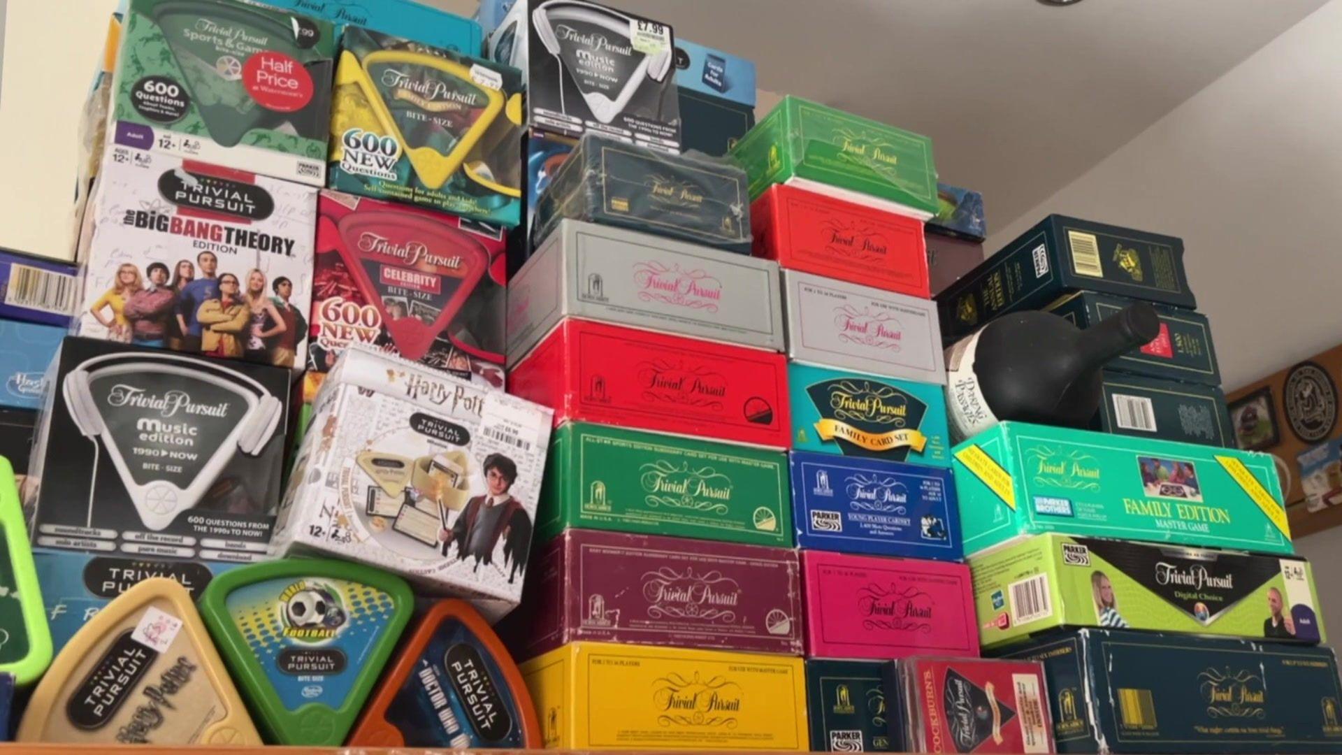 Several boxes of the Trivial Pursuit board game stacked on top of each other.