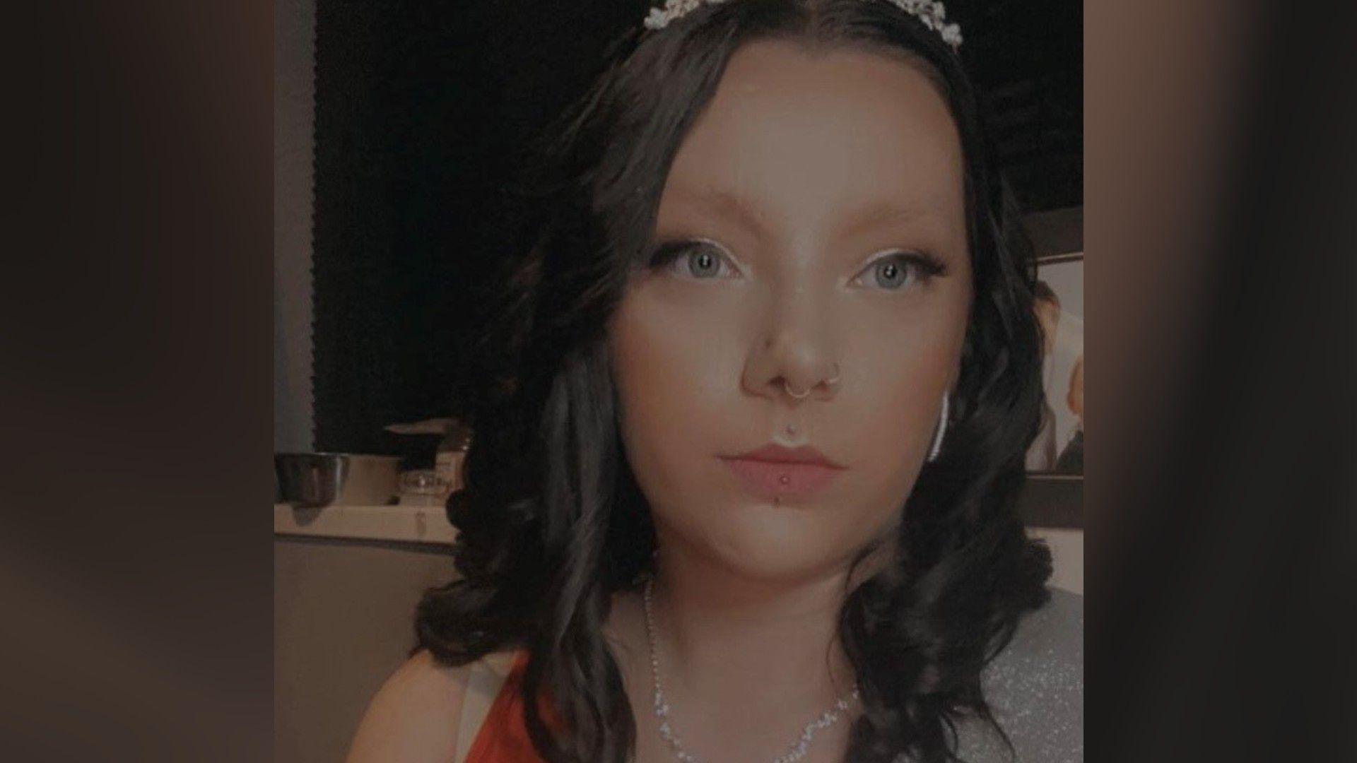 Billie wearing a sleeveless sparkly top and a a tiara on her hair- taking a selfie