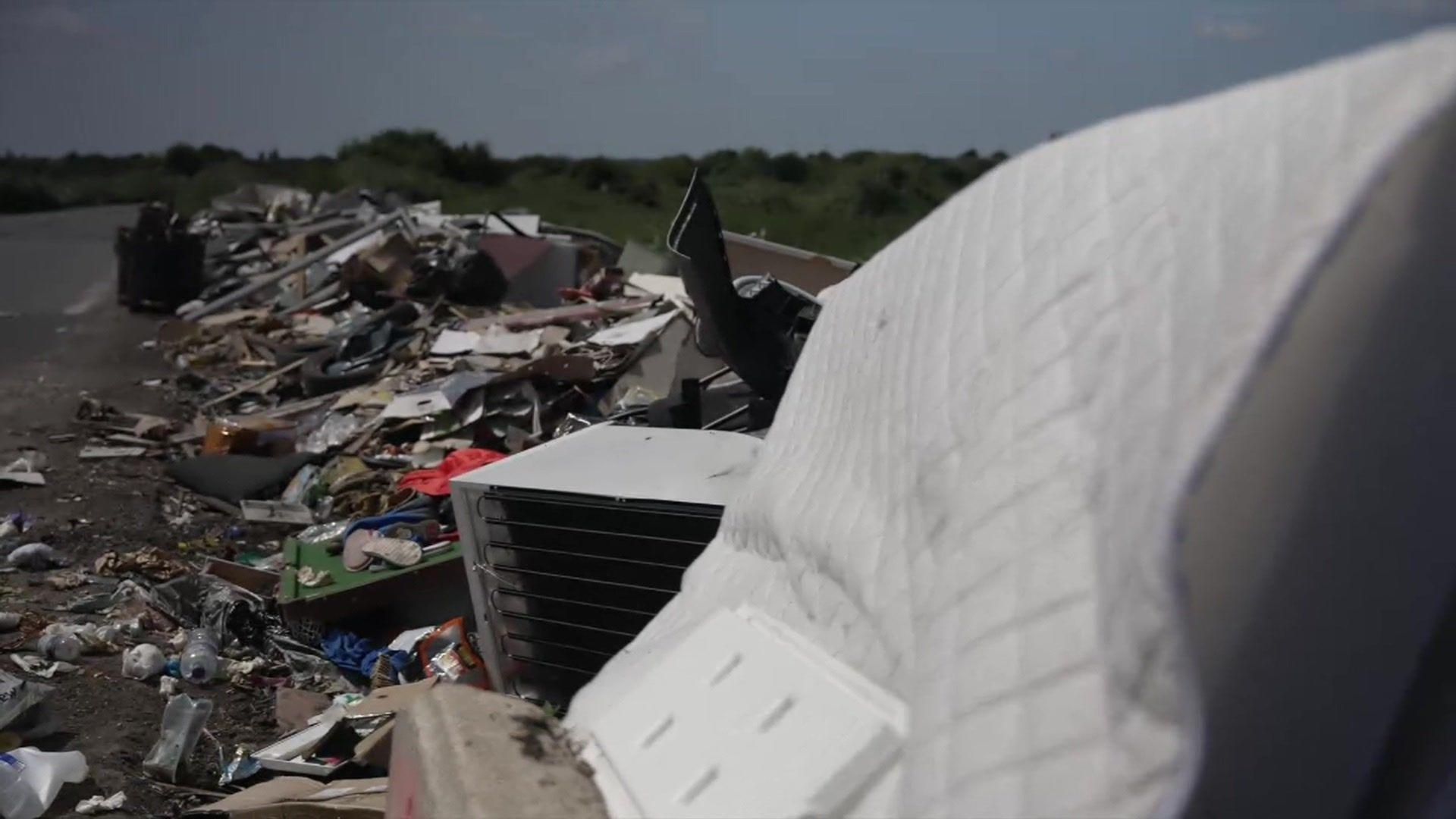 Images showing a mattress and fridge at the front of a long line of rubbish on a road in Bexley