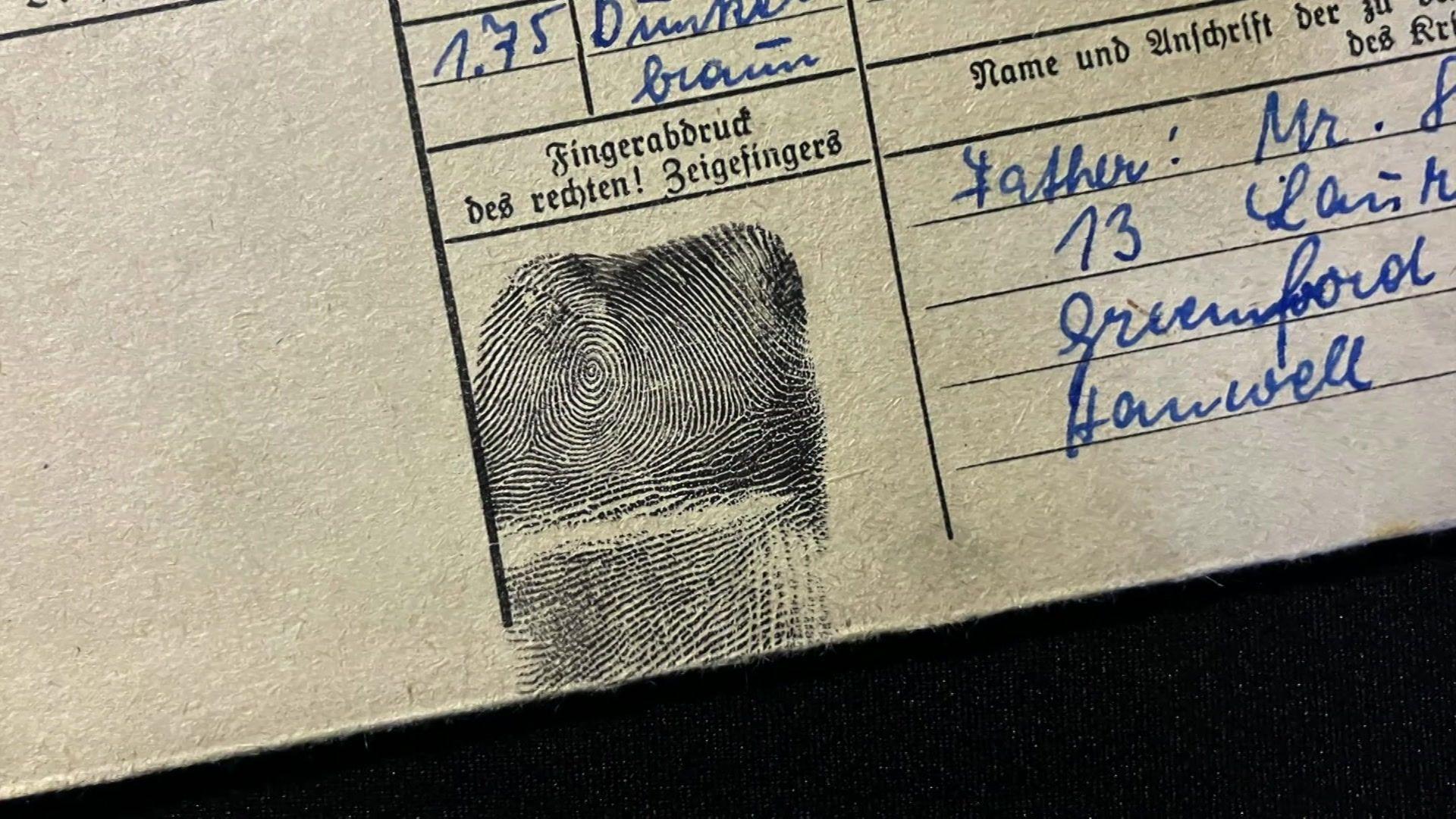 A scanned image of a document with black print in German that reads "right-hand forefinger", handwriting in blue ink, and a black ink thumb print