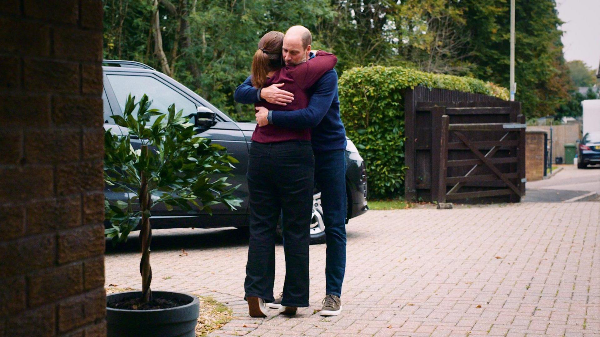 Prince William and Rhian Mannings hugging in her driveway in Cardiff. There is a black range rover in the background.