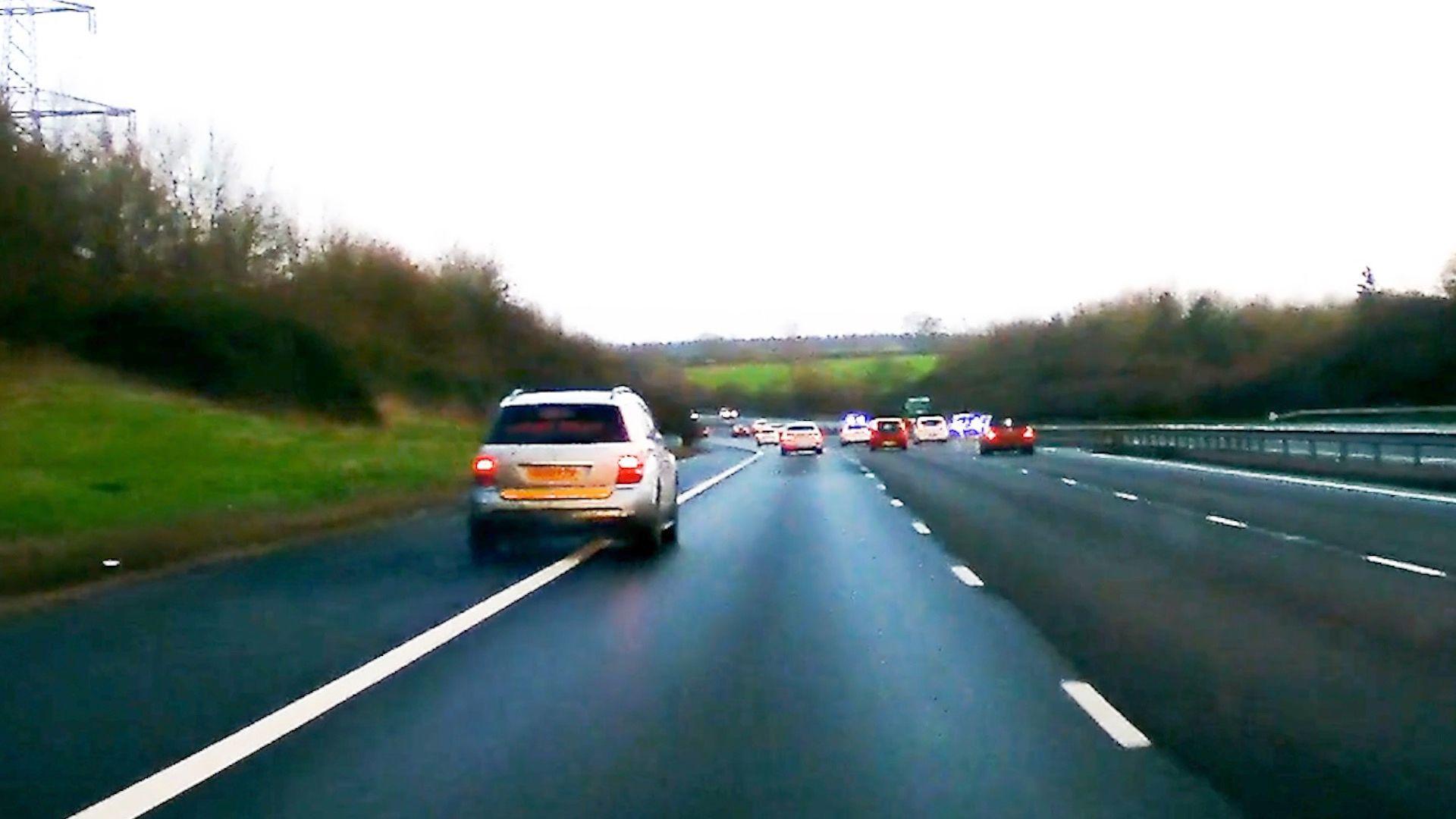 An image of a speeding car driving on the hard shoulder of the motorway