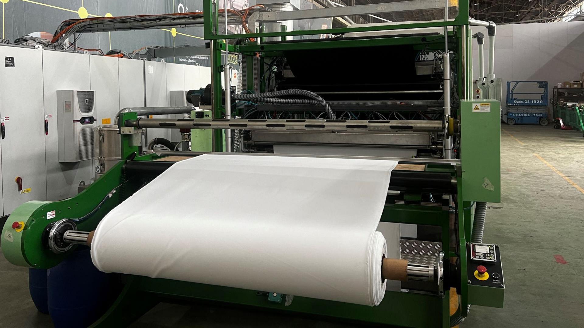 A roll of white cloth sits on Alchemie's new dyeing machine