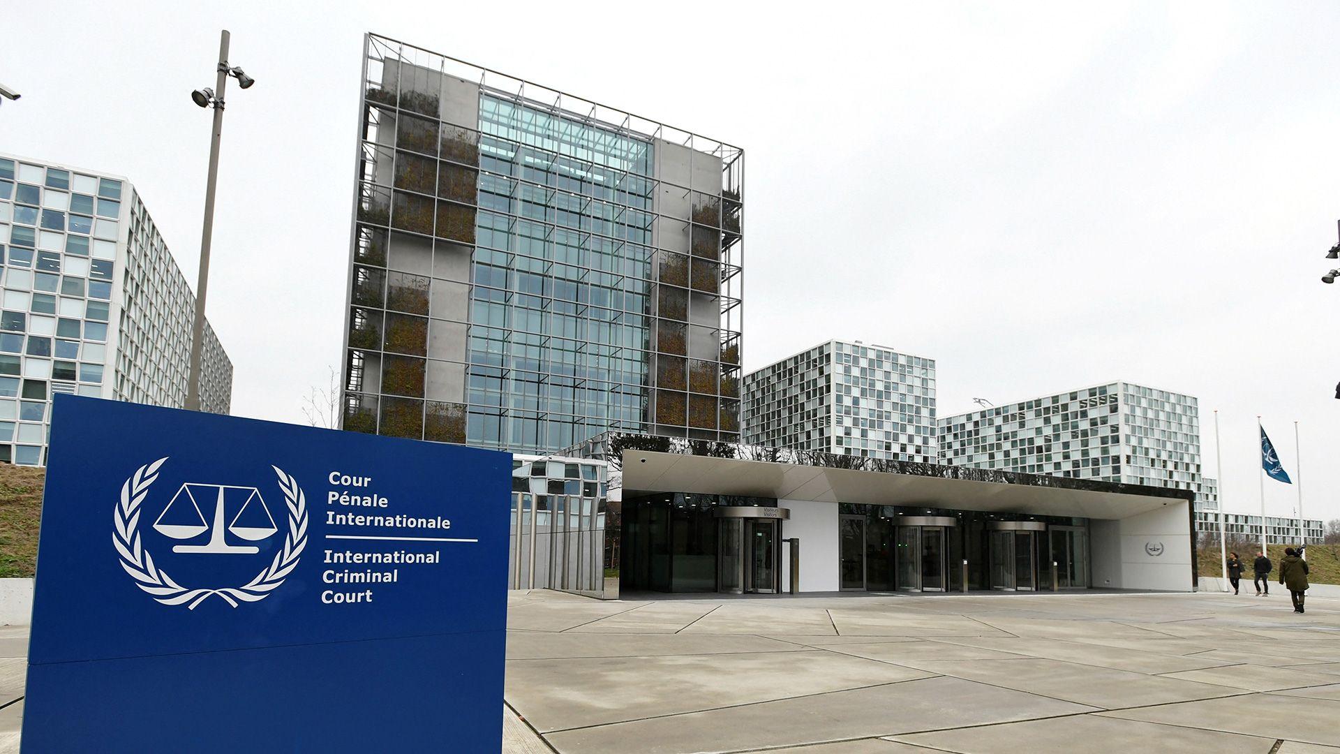 A glass building with a piazza and a blue sign reading International Criminal Court