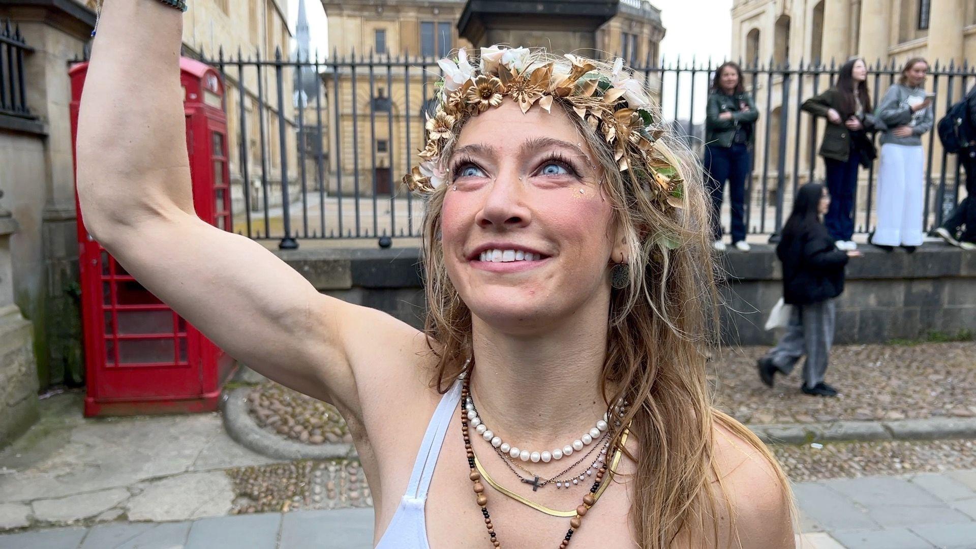 A woman with blonde hair and a golden crown made of leaves