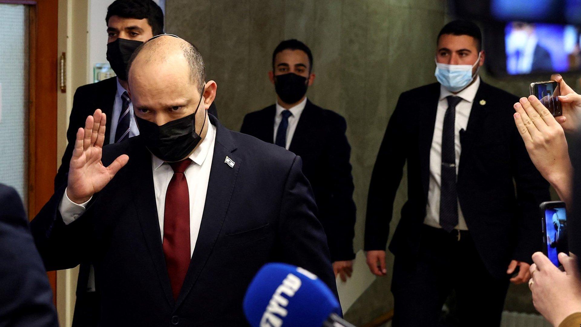 Israeli Prime Minister Naftali Bennett waves to reporters as he arrives at a cabinet meeting in Jerusalem on 6 March 2022