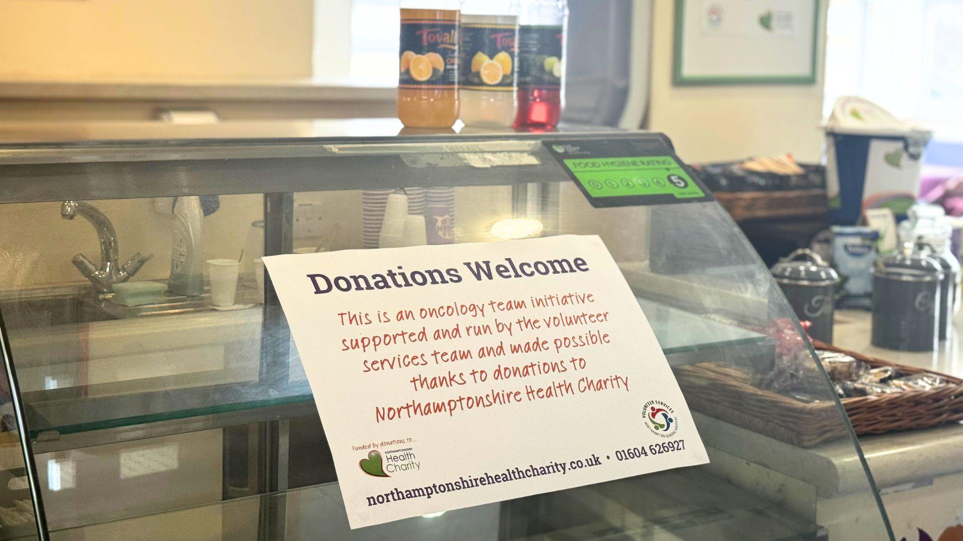 Donations Welcome sign on chilled counter in cafe