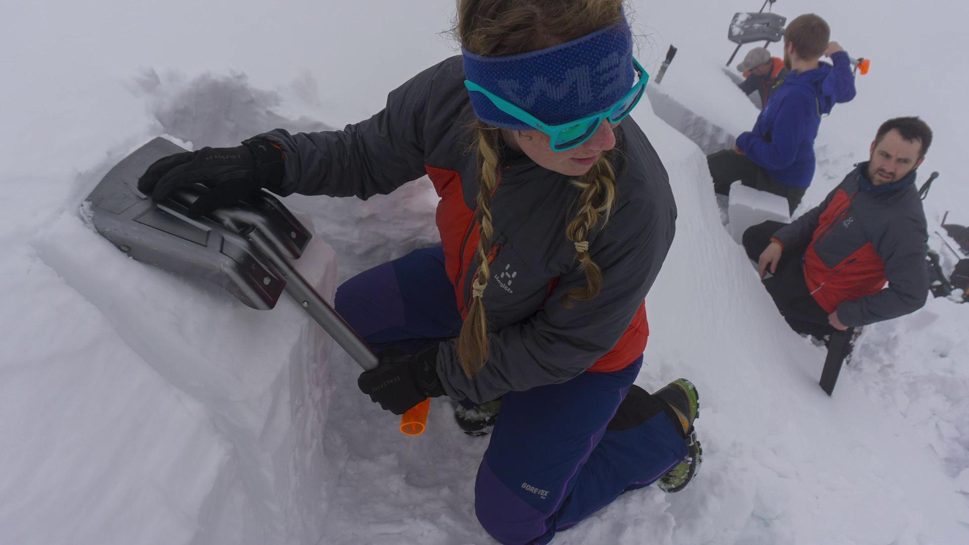 Young woman shovelling snow
