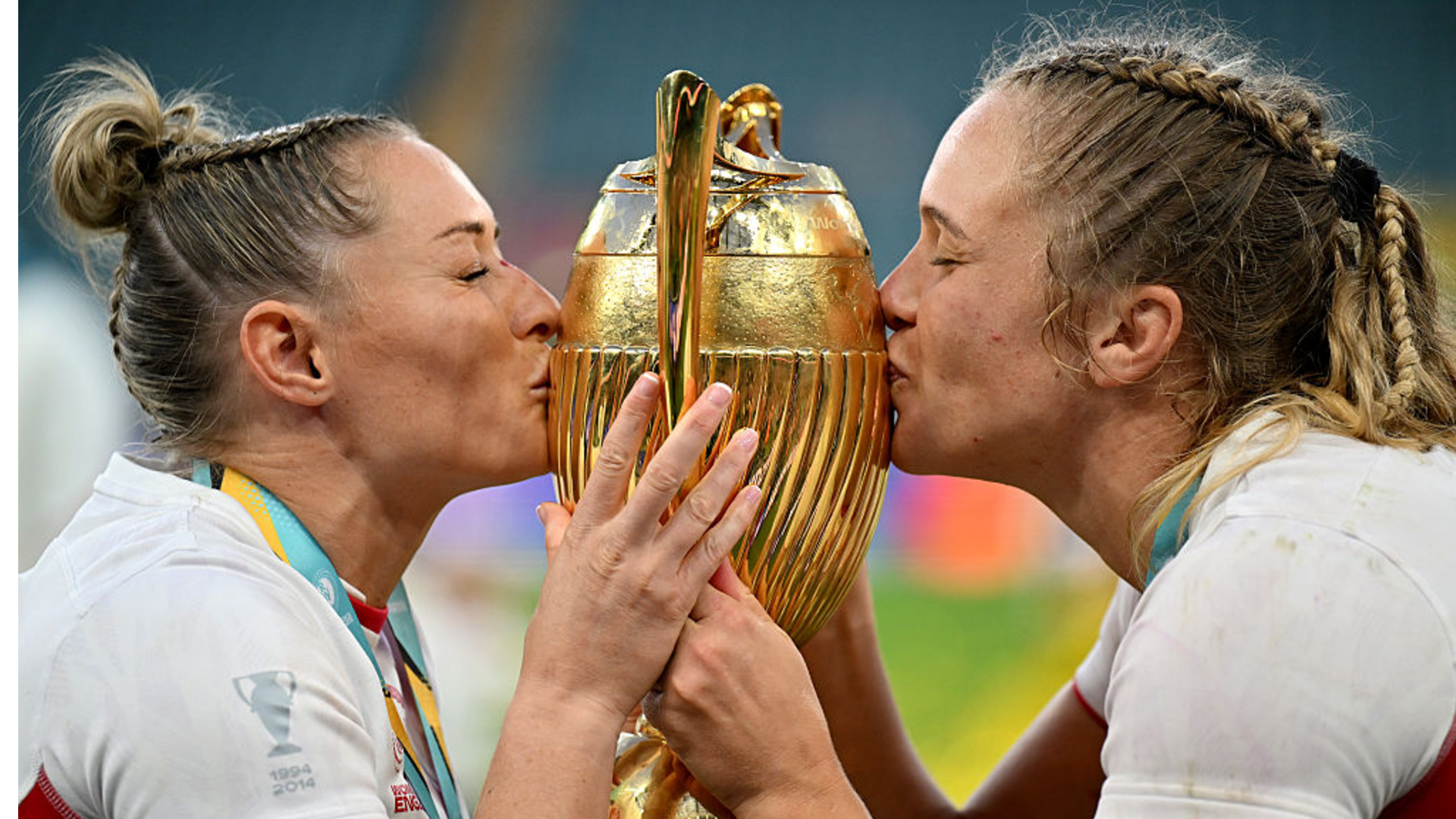 Natasha Hunt and Zoe Aldcroft kissing rugby world cup trophy.