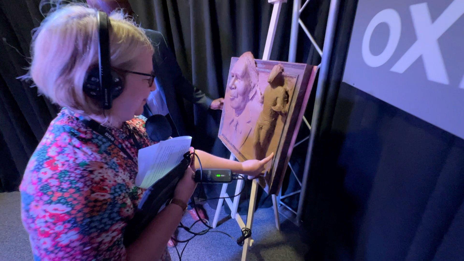 Sophie Law adding clay to Sir Roger Bannister sculpture