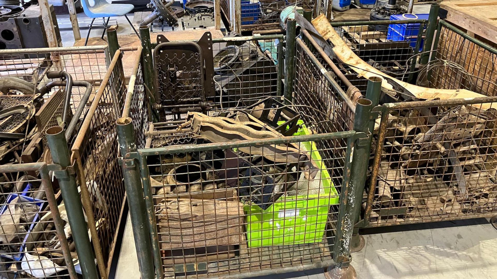 3 metal crates are full of bits and pieces that were stripped from the tank. They look like three piles of scrap metal