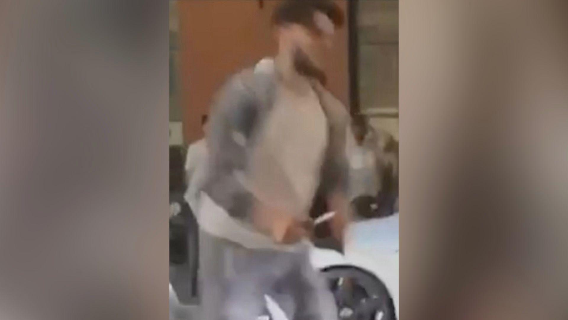 Connor Page shown on CCTV footage holding a weapon during an attack in June 2024, The image is blurred but a man can be seen wearing a grey sweatsuit with a white t-shirt and they are carrying what appears to be a sharp object in the left hand.