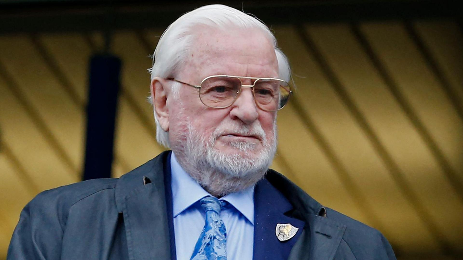 Former Chelsea and Leeds United owner Ken Bates in blue shirt and tie, with a Chelsea club badge on his jacket