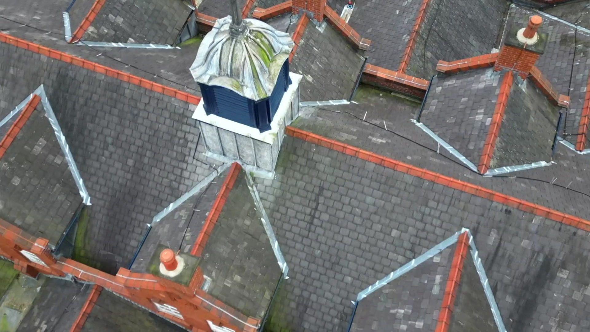 An aerial picture looking down on a school roof, with some damp patches in places