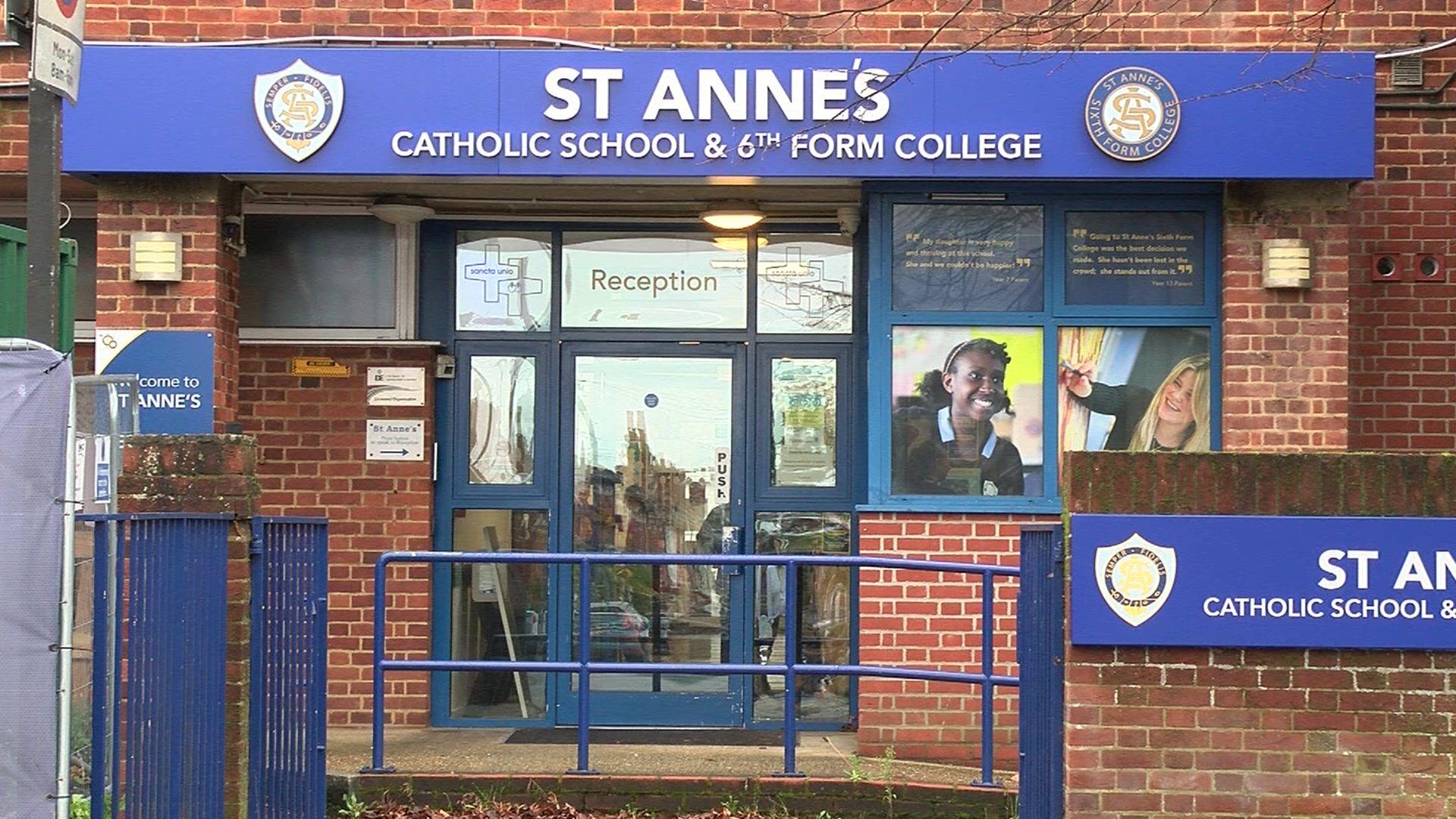 The front of St Anne's - which is red brick with large blue signage and a large glass doorway with blue trims.