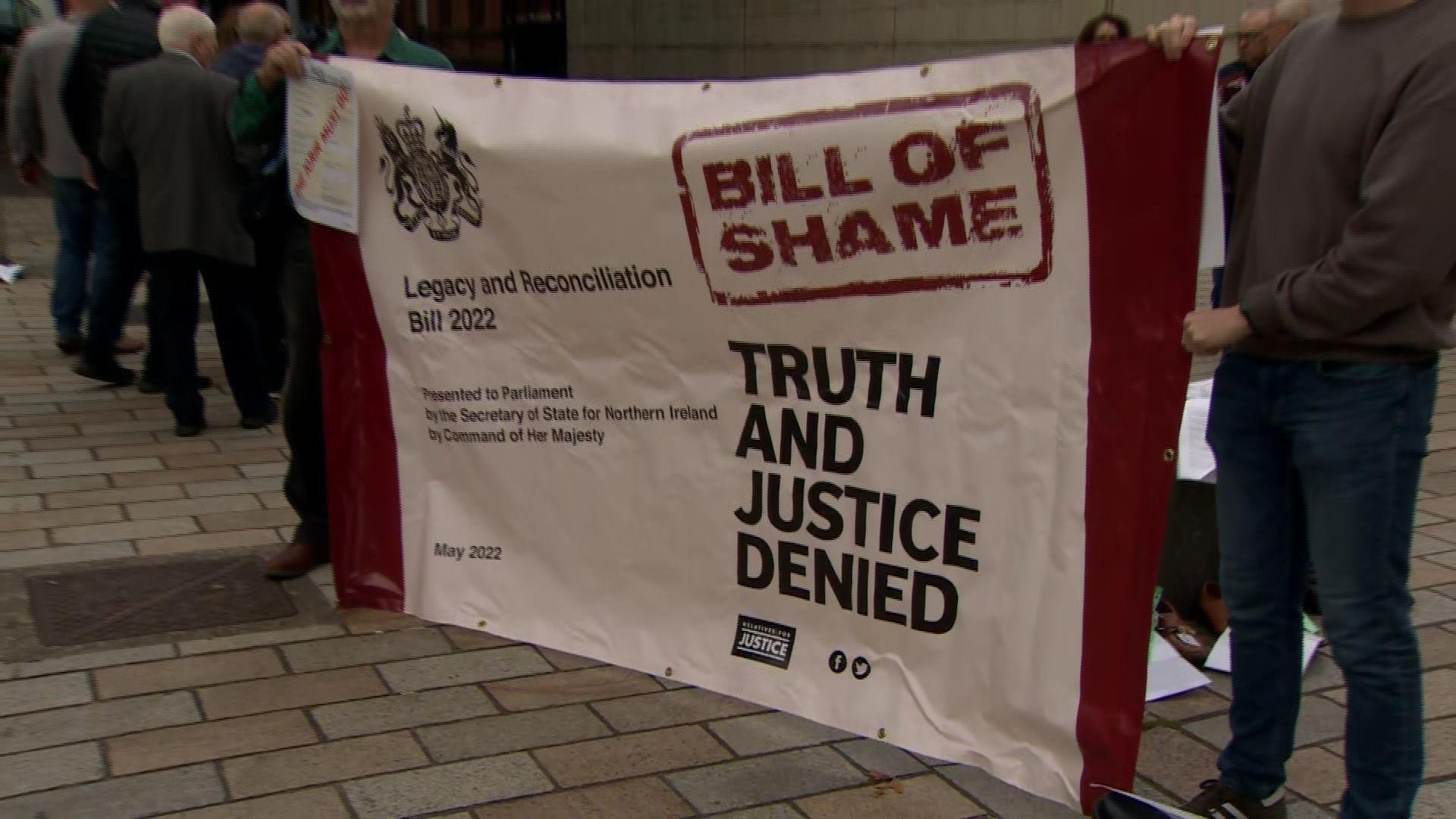 A banner saying 'Bill of shame' and 'truth and justice denied' 