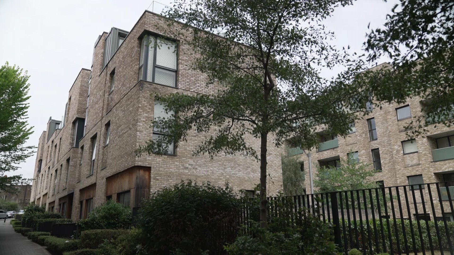 Outside the housing block where Andre Louis lives with trees in the foreground