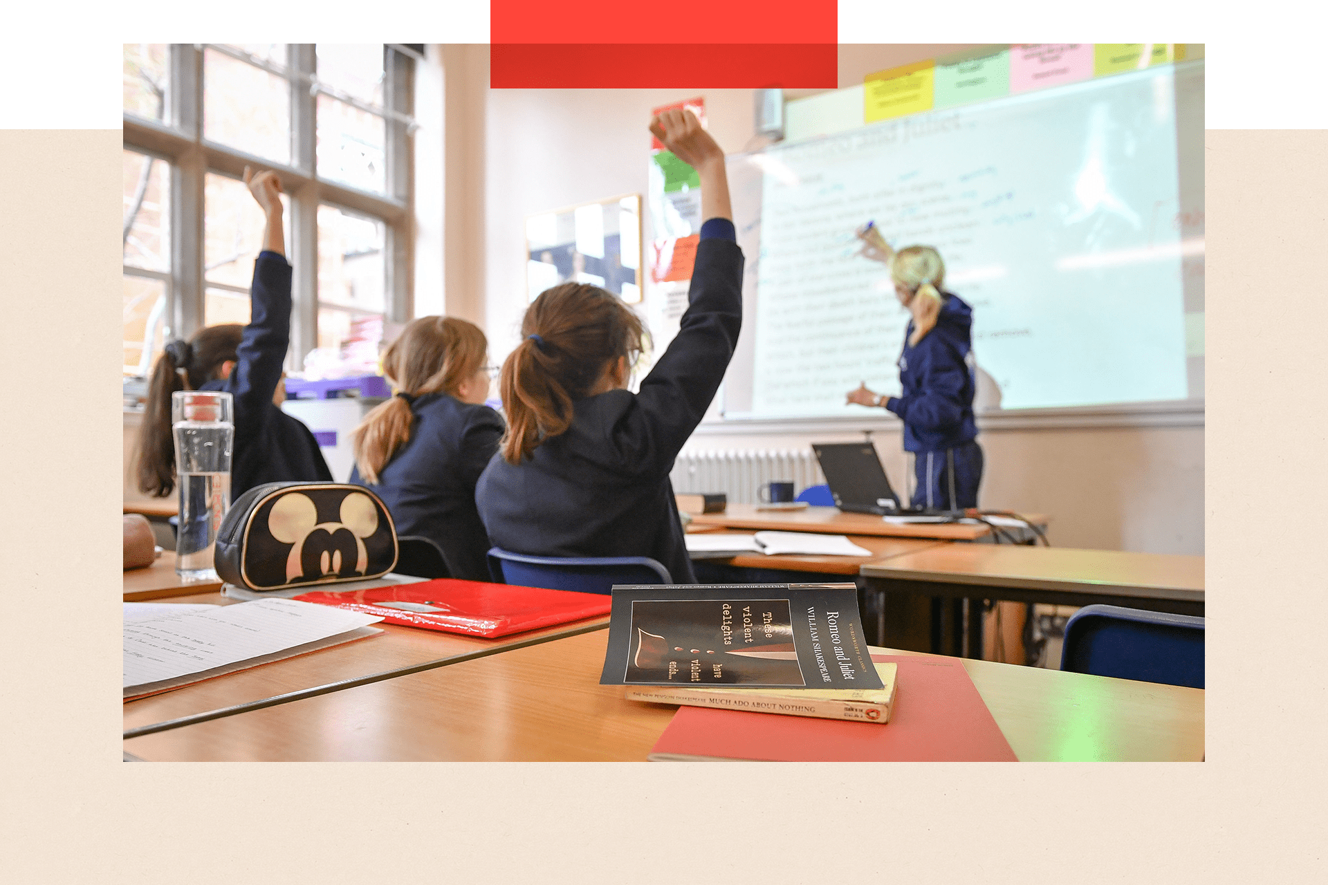 Children putting their hands up in a classroom 