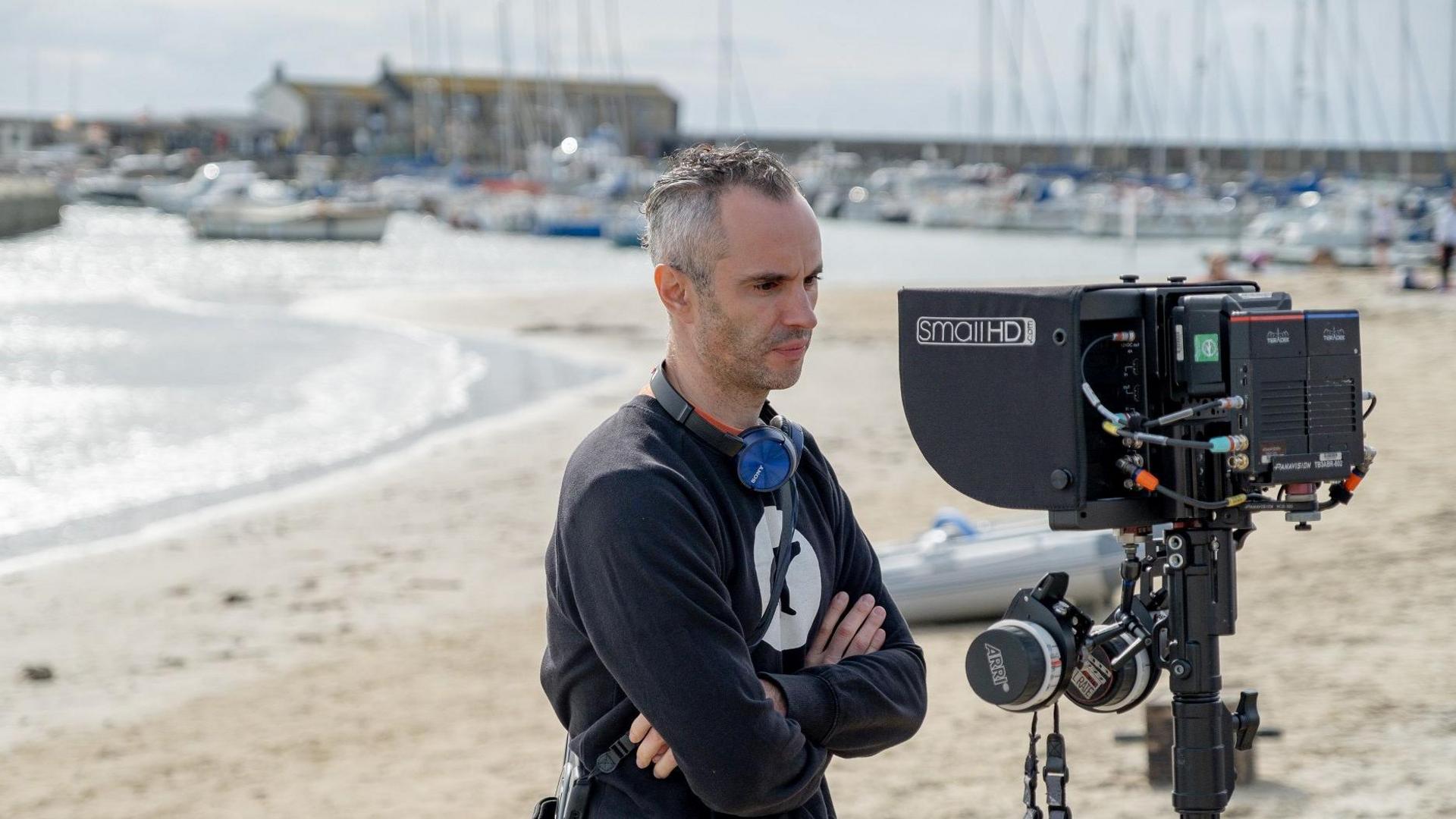 Andy on a beach, looking at a camera