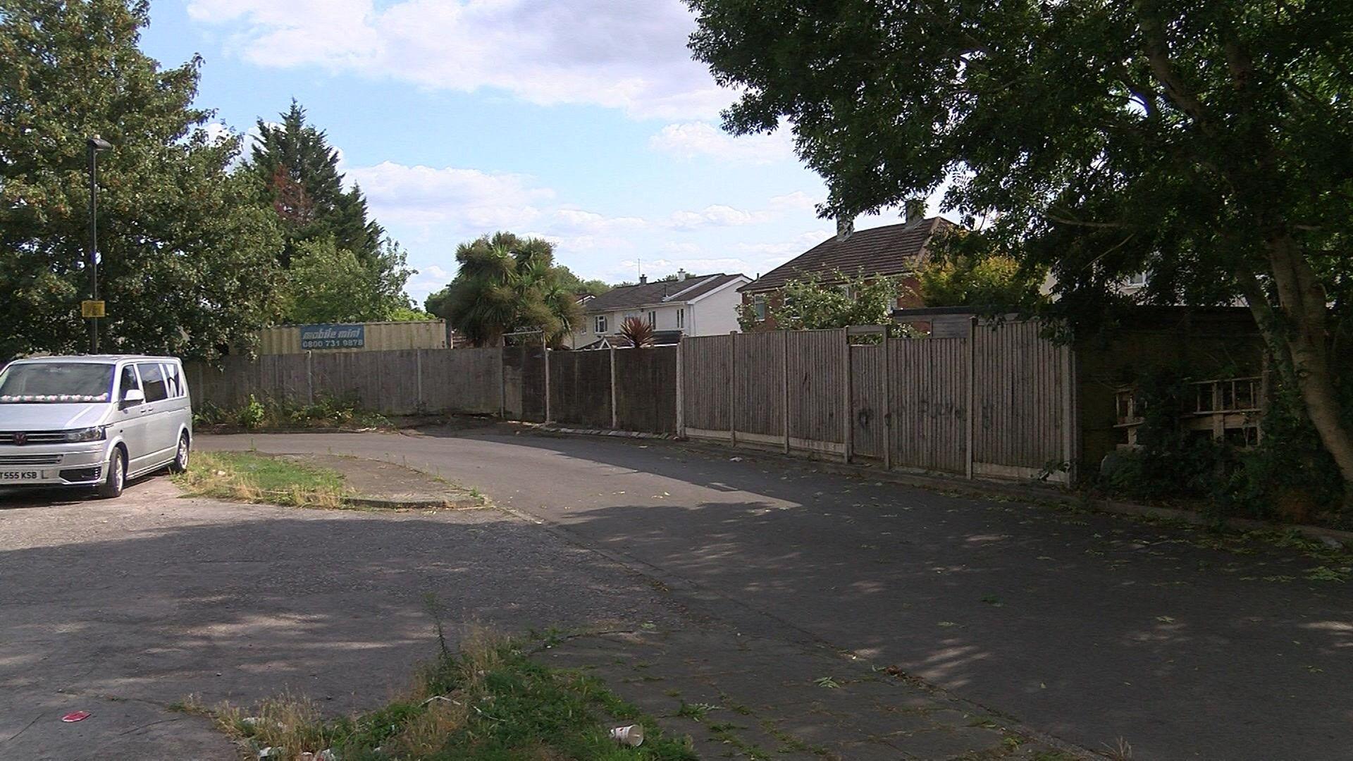A view of Montague Avenue - a small road alongside a line of fences at the back of houses