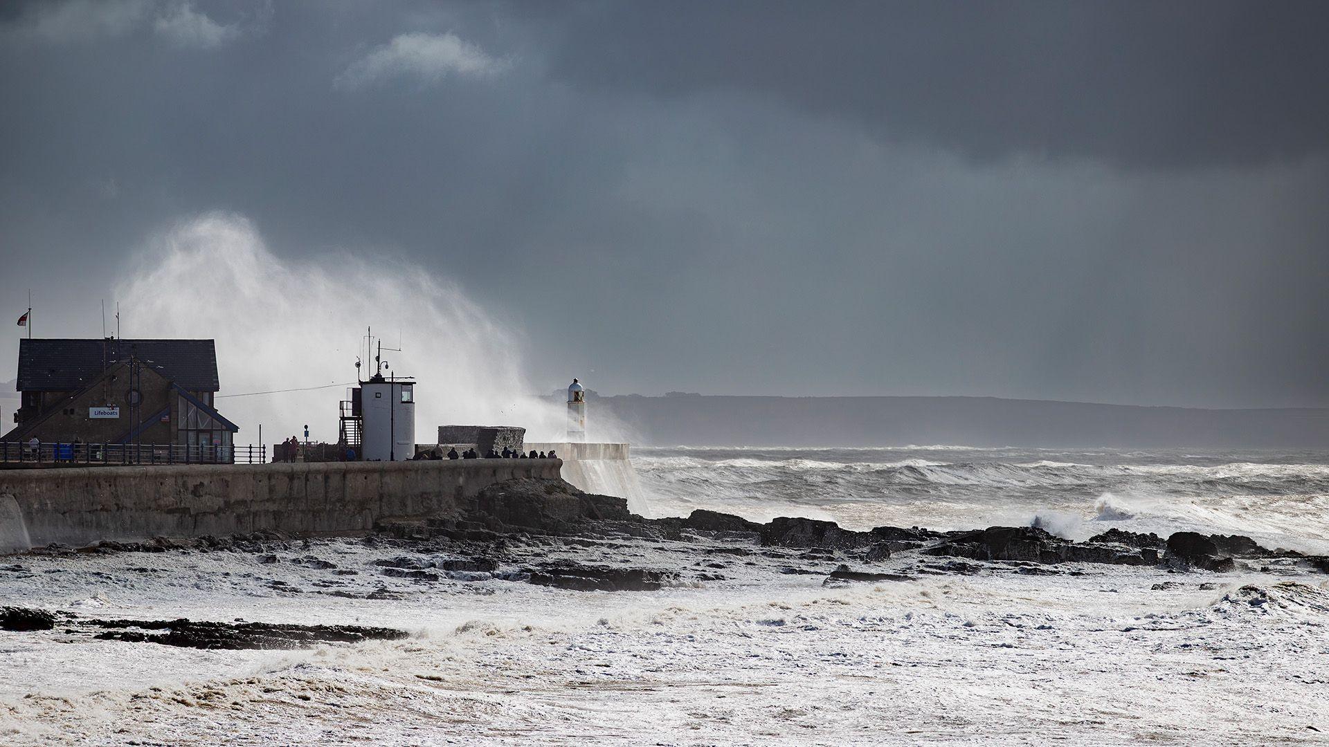 The waves on the Welsh cast are crashing . The sky is dark and stormy