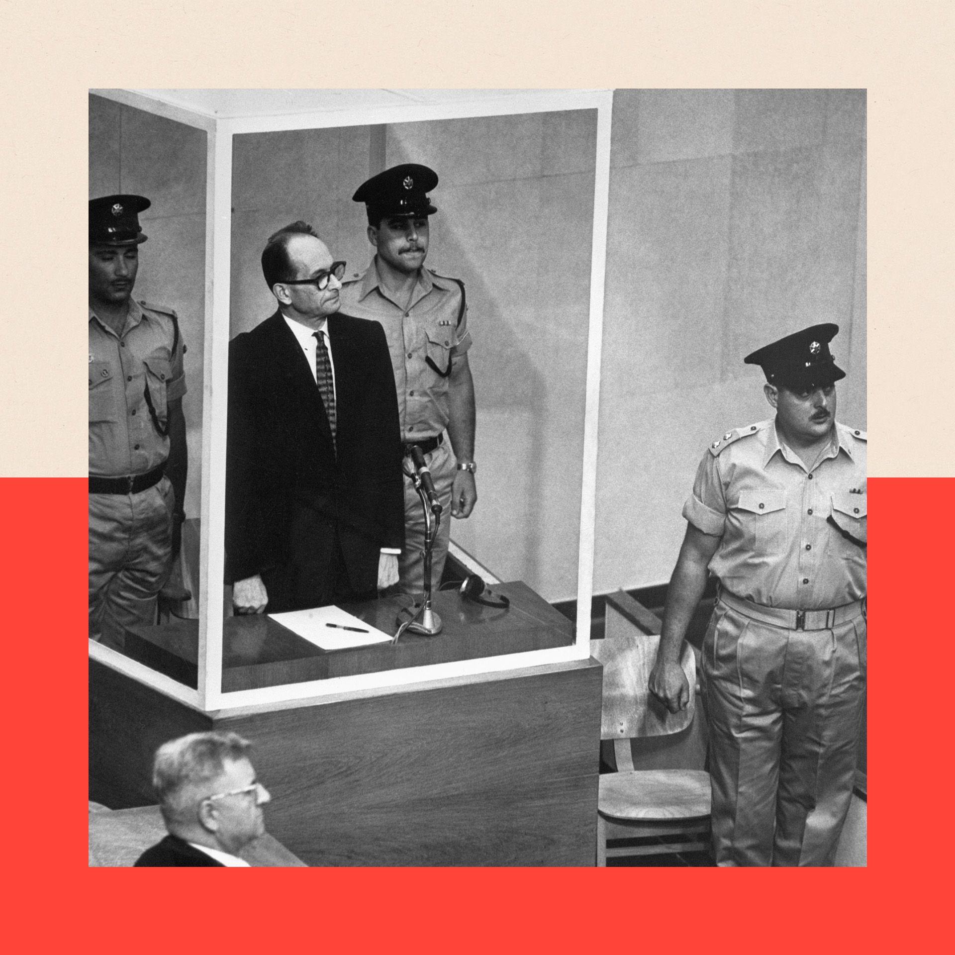 Adolf Eichmann stands in his bullet-proof glass cage to hear Israel's Supreme Court unanimously reject an appeal against his death sentence. With him are two armed guards. 