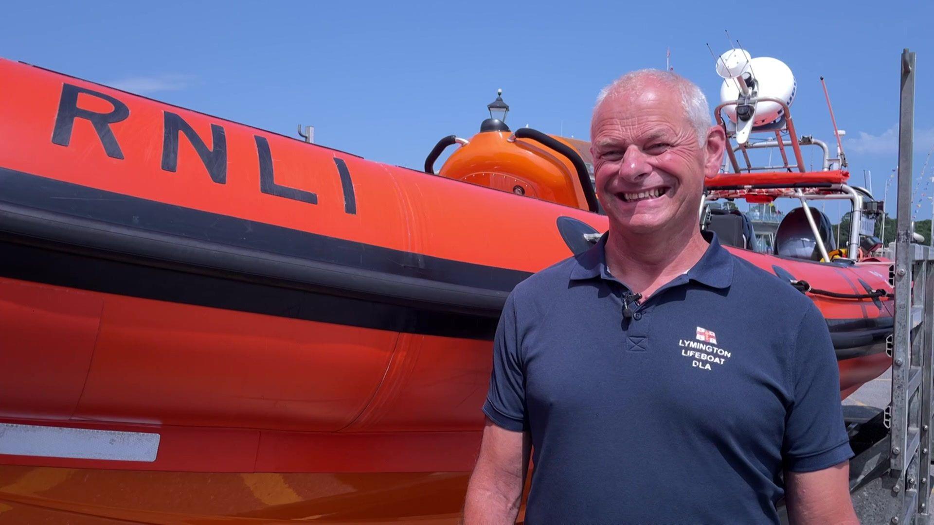 Nick Hayward, stood next to an RNLI lifeboat and smiling