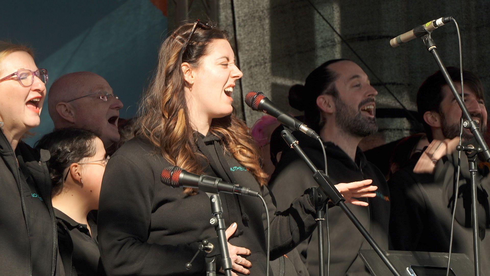 Choir members, singing into microphones.