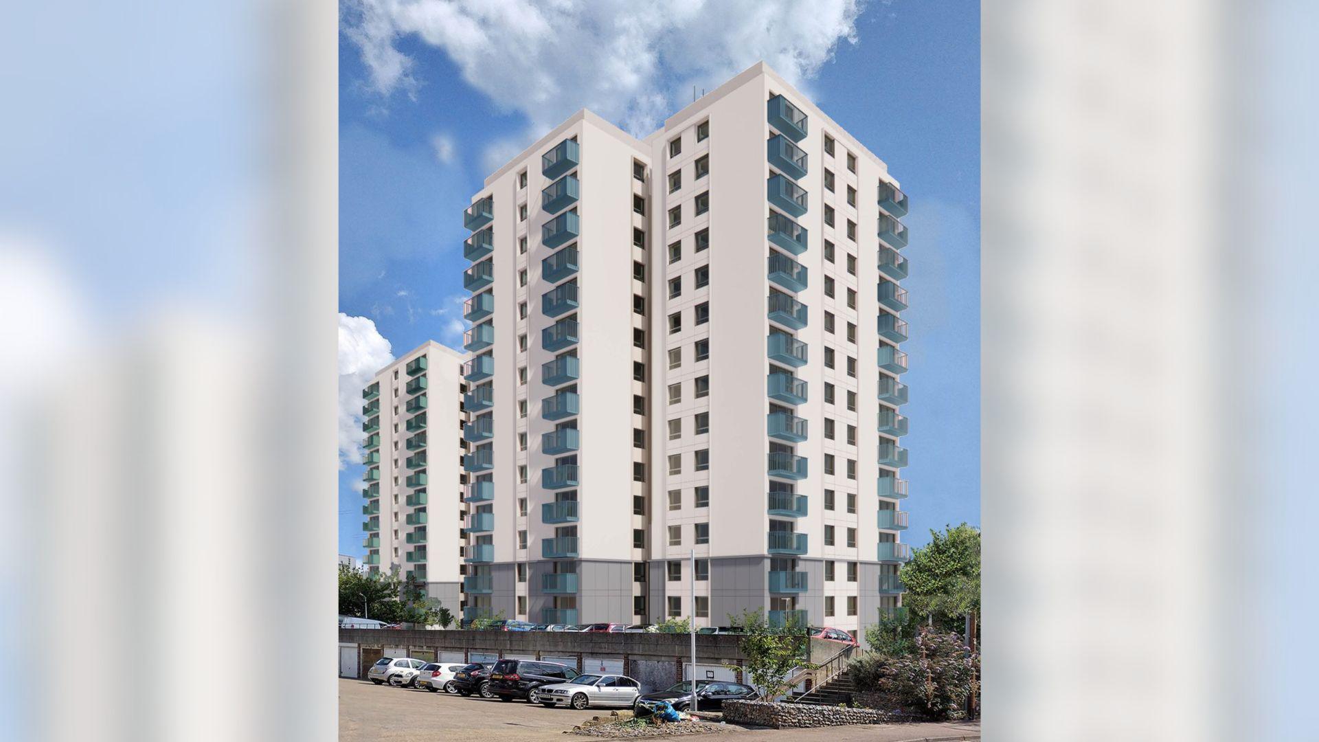 Two tower blocks. They are the same two as the top image of this article. This time, the cream render is clean and the balconies are coloured blue and green. The sky behind is blue with a few clouds.